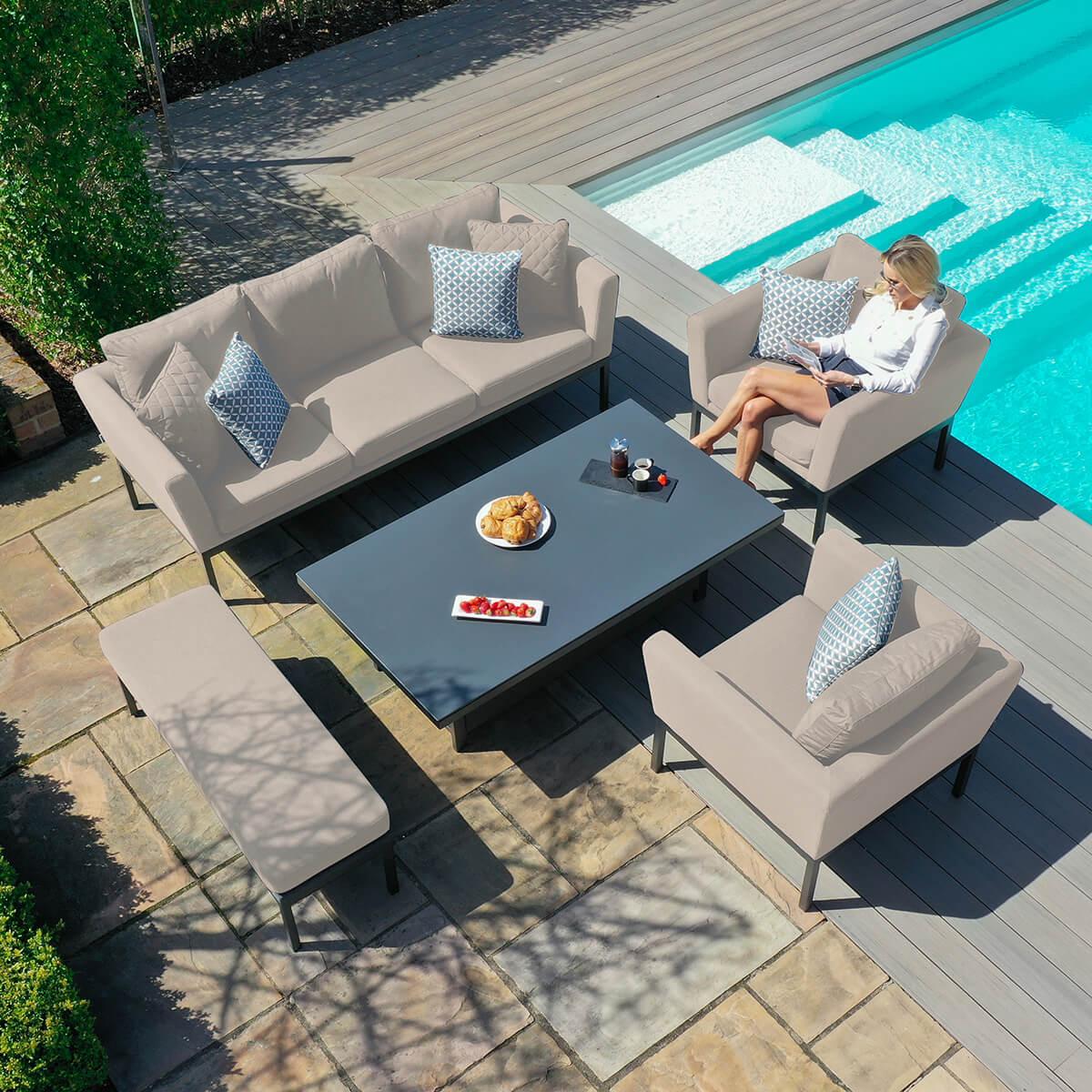 Beige outdoor sofa set with table and armchairs by pool on patio