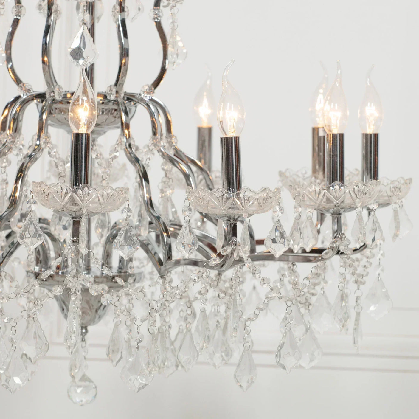 Crystal chandelier with chrome frame and candle-style lights, detailed close-up view