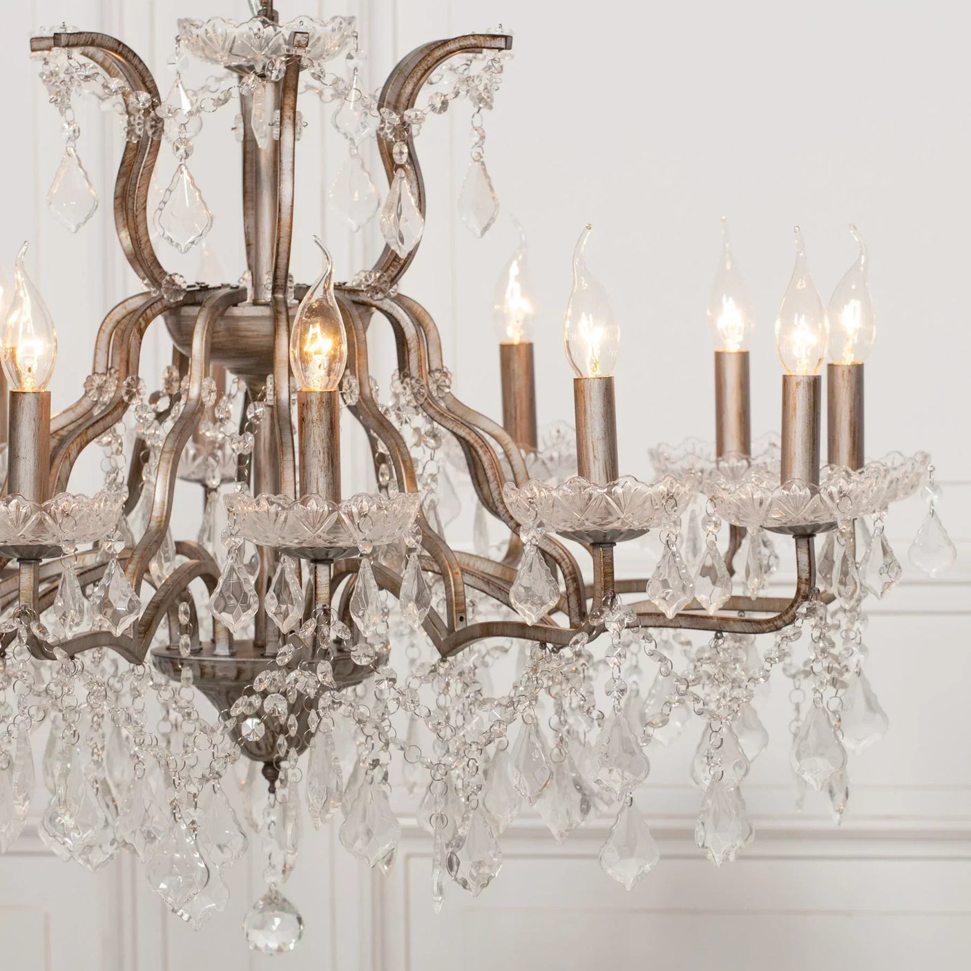Crystal chandelier with eight candle lights and hanging glass droplets in elegant room