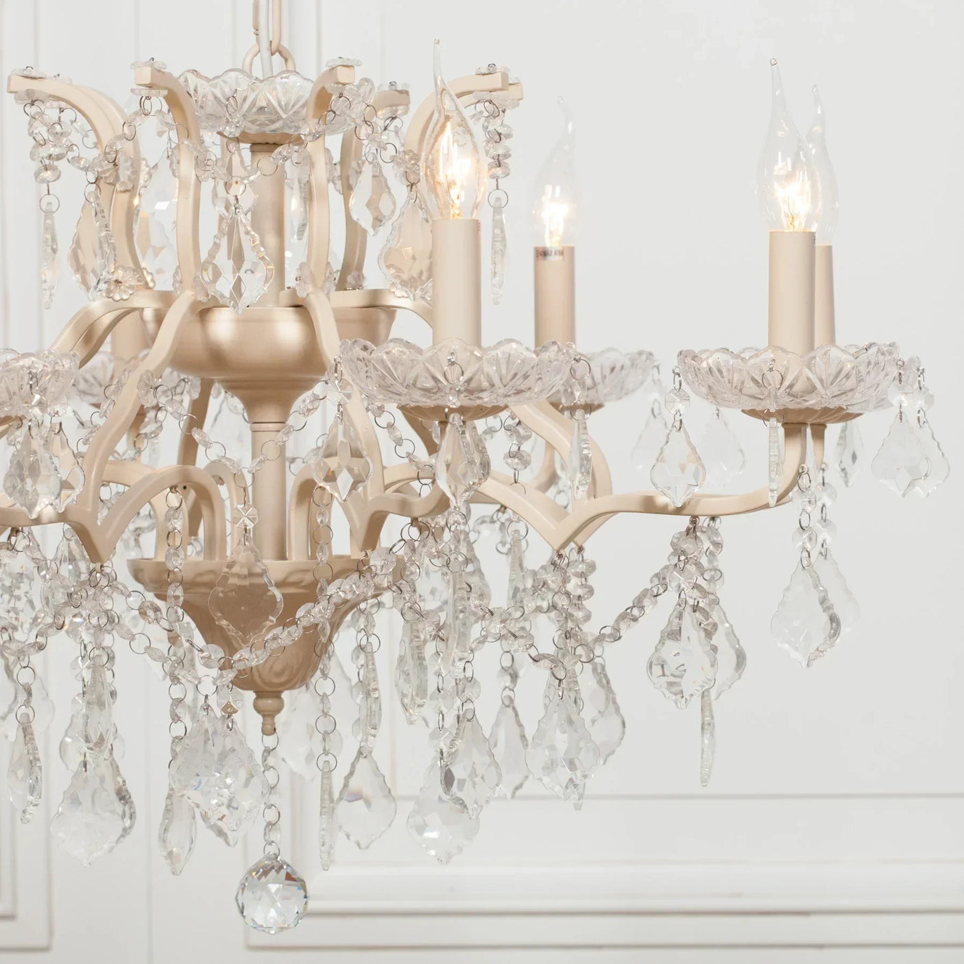 Cream crystal chandelier with candle bulbs and hanging glass droplets