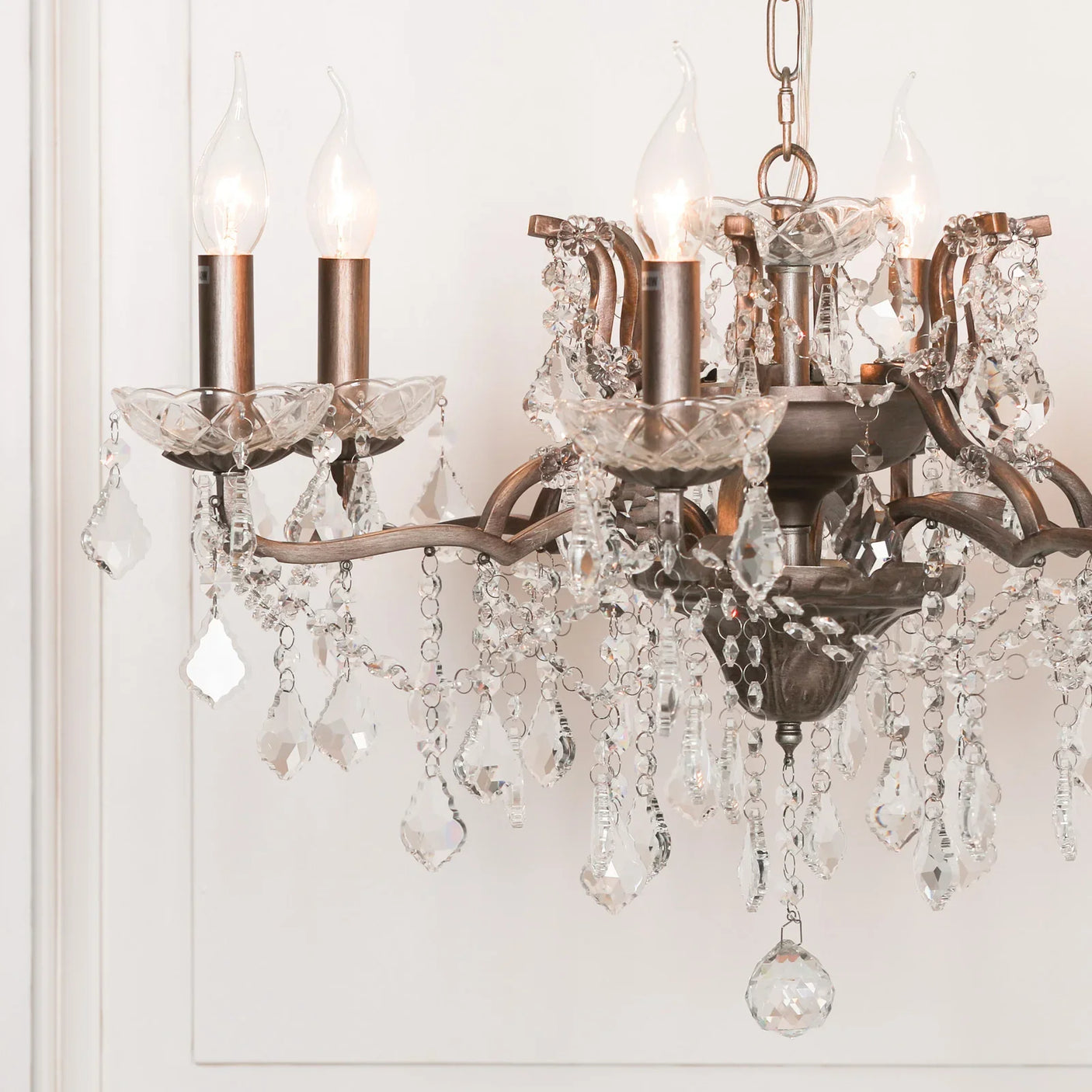 Vintage crystal chandelier with candle-style bulbs and ornate hanging glass pendants