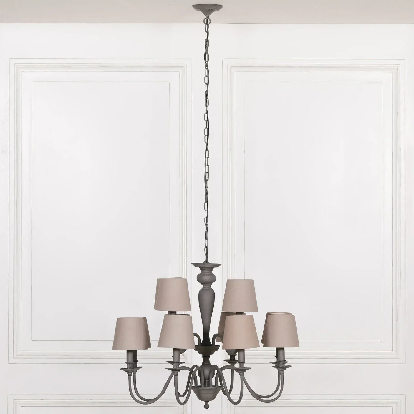 Six light grey metal chandelier with taupe fabric shades, suspended on chain in bright room