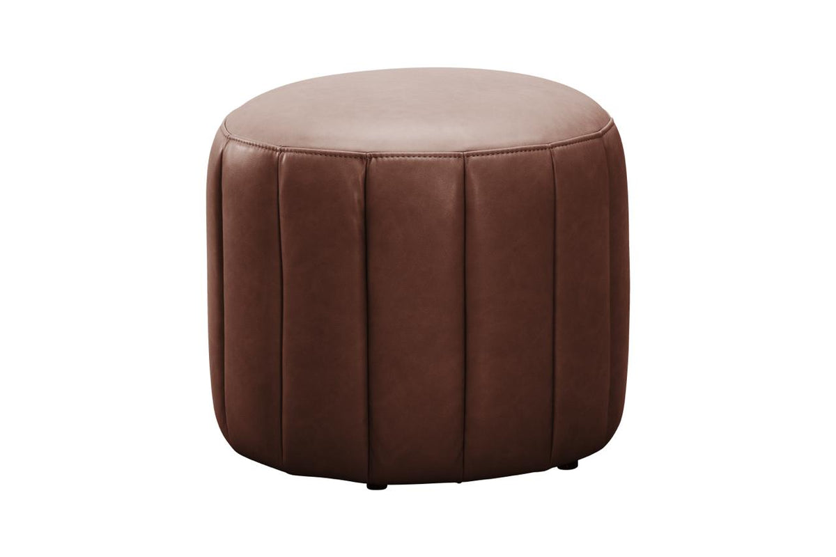 A round brown faux leather ottoman with vertical channel tufting on a solid white background.