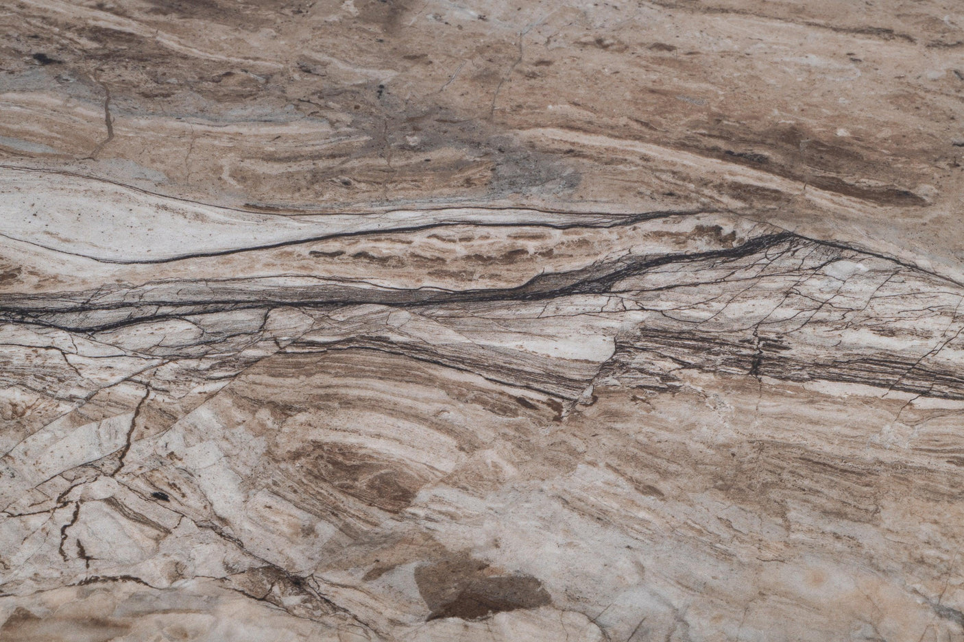 Close up of marble tabletop with brown, beige, and black natural stone veining detail