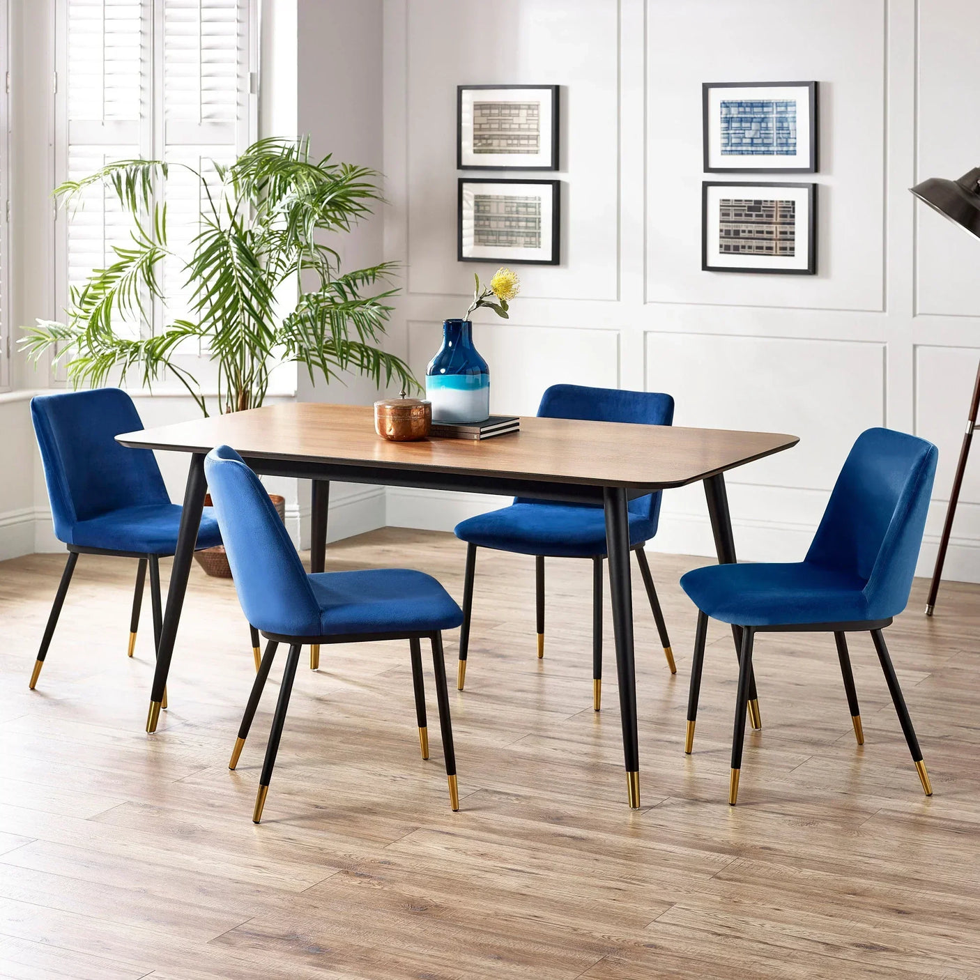 Modern dining table set with blue velvet chairs and wood top in bright dining room