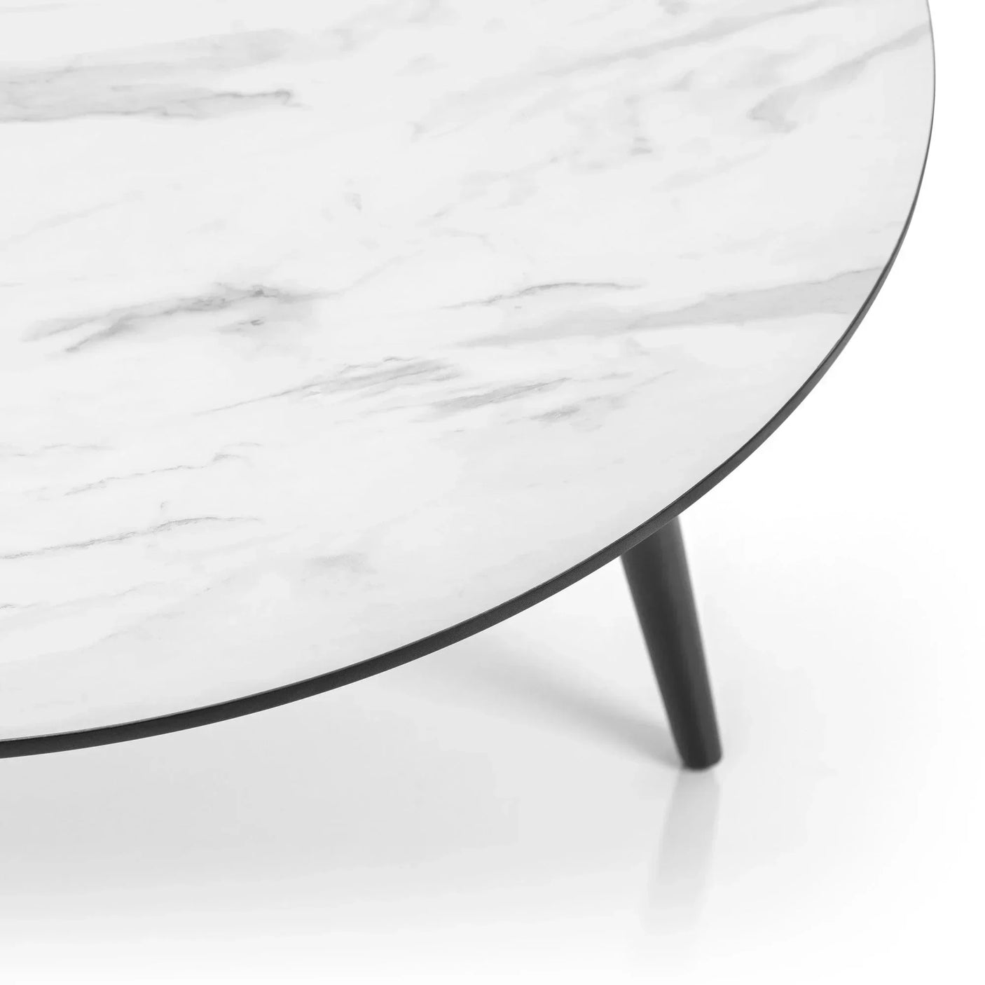 Round coffee table with white marble effect top and black angled legs, close-up view