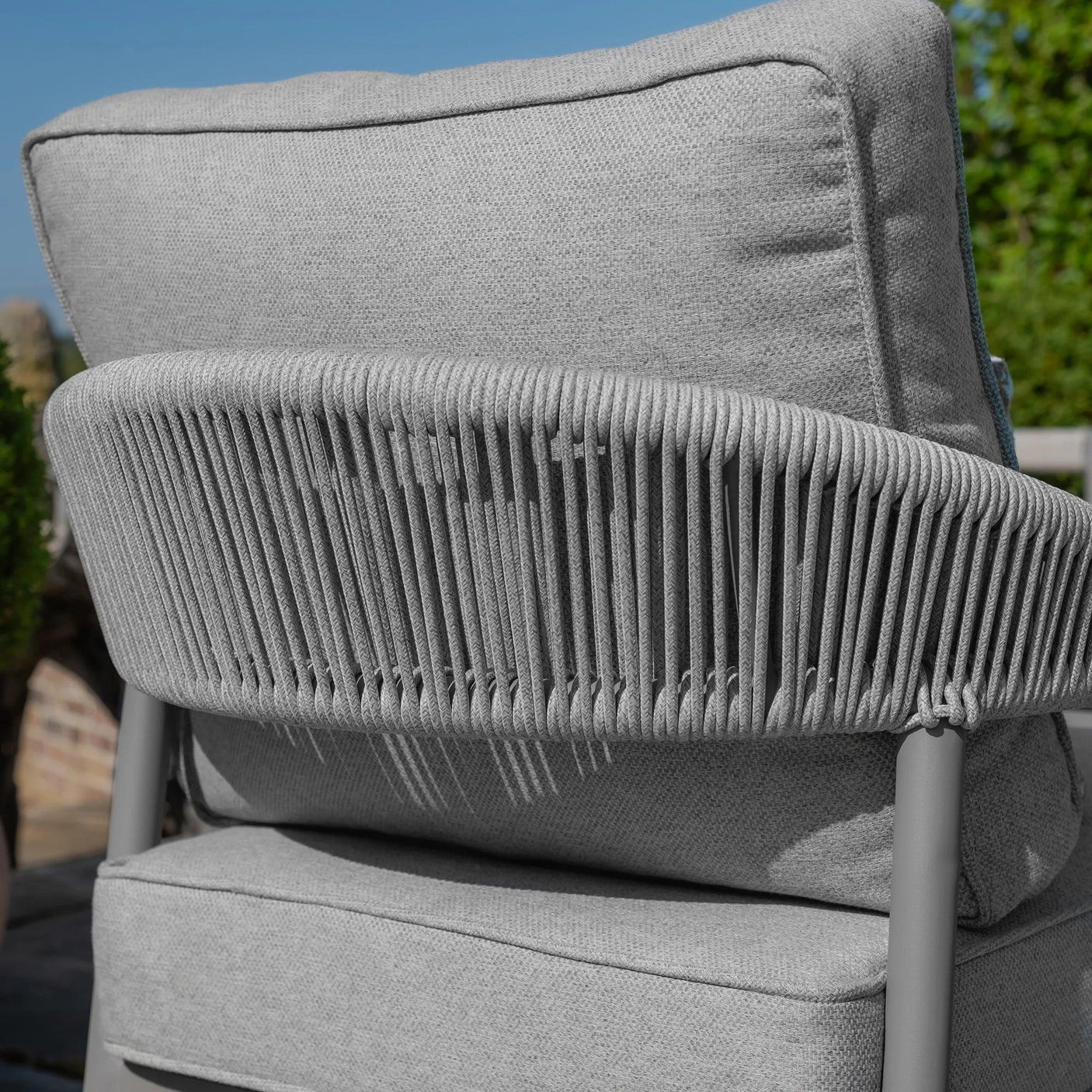 Close up of grey rope outdoor lounge chair with textured cushion and metal frame