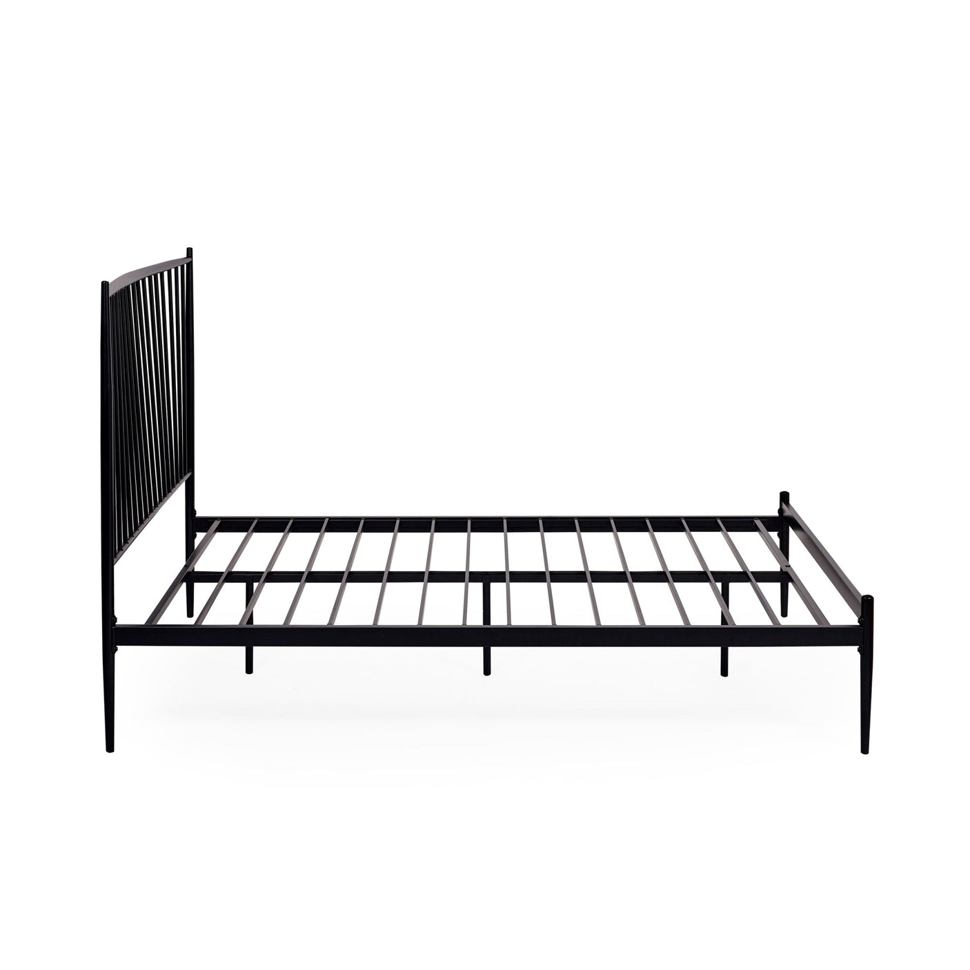 Close-up angled side view of black metal spindle bed with white bedding and beige pillows in soft light