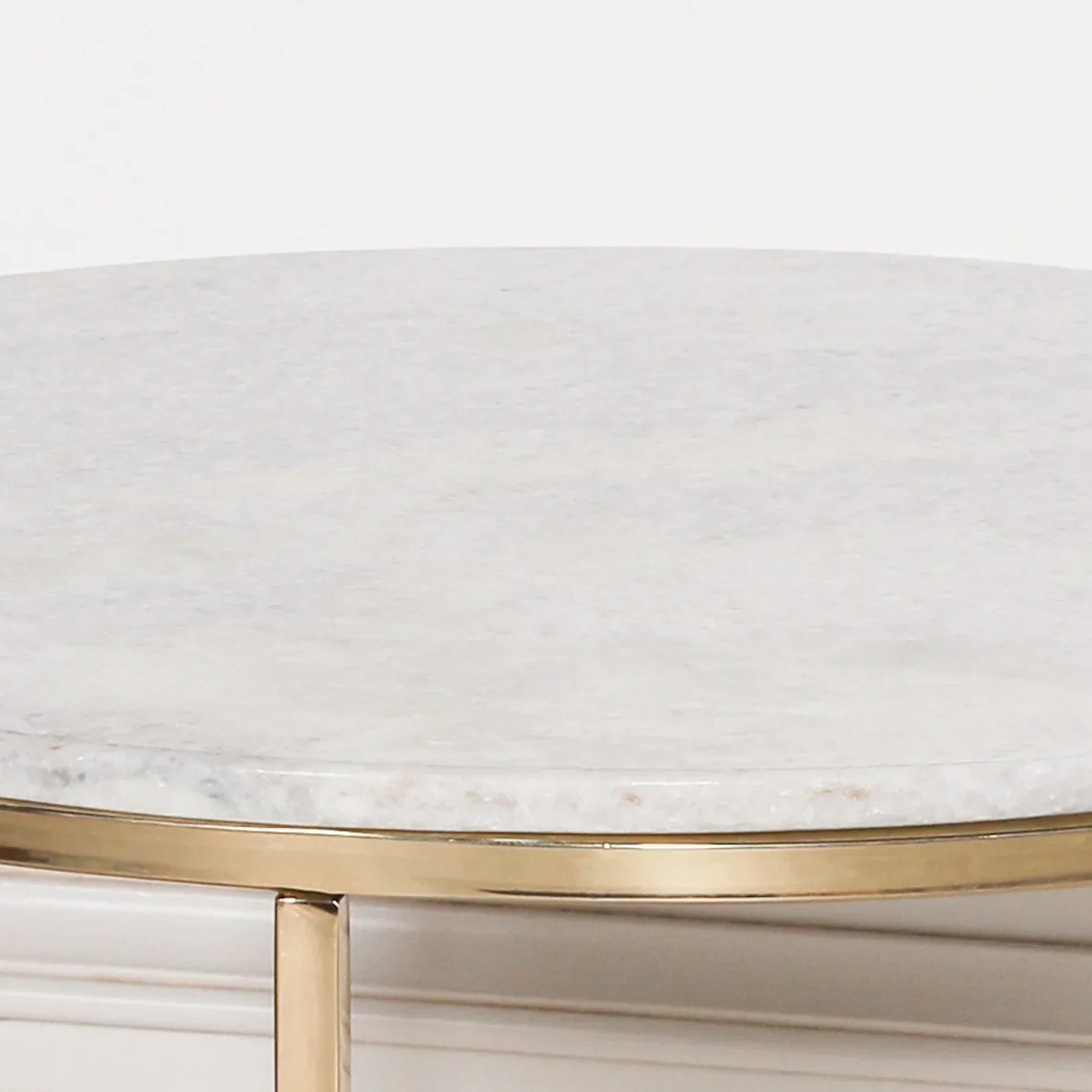 Round white marble tabletop with gold metal trim detail