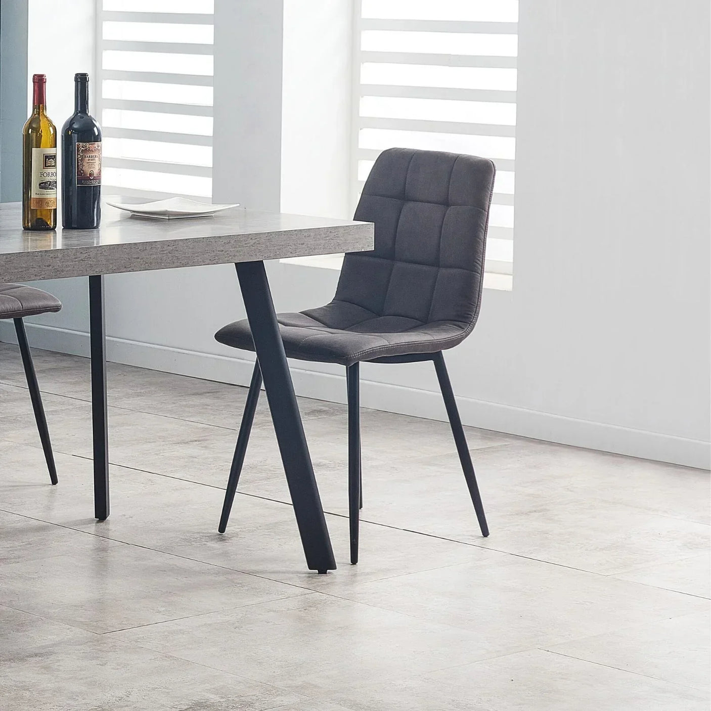 Grey fabric dining chair with black metal legs next to rectangular table in modern dining room