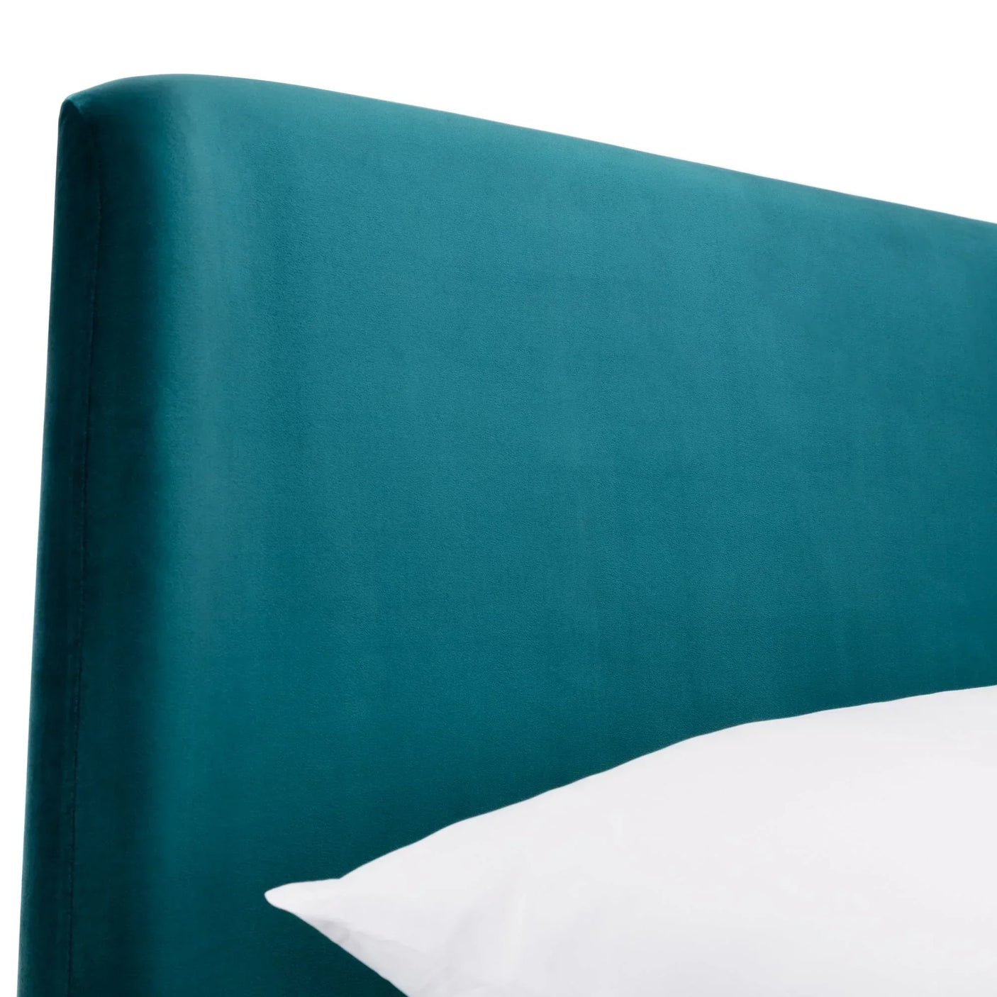 Teal velvet king bed headboard close-up with white pillow