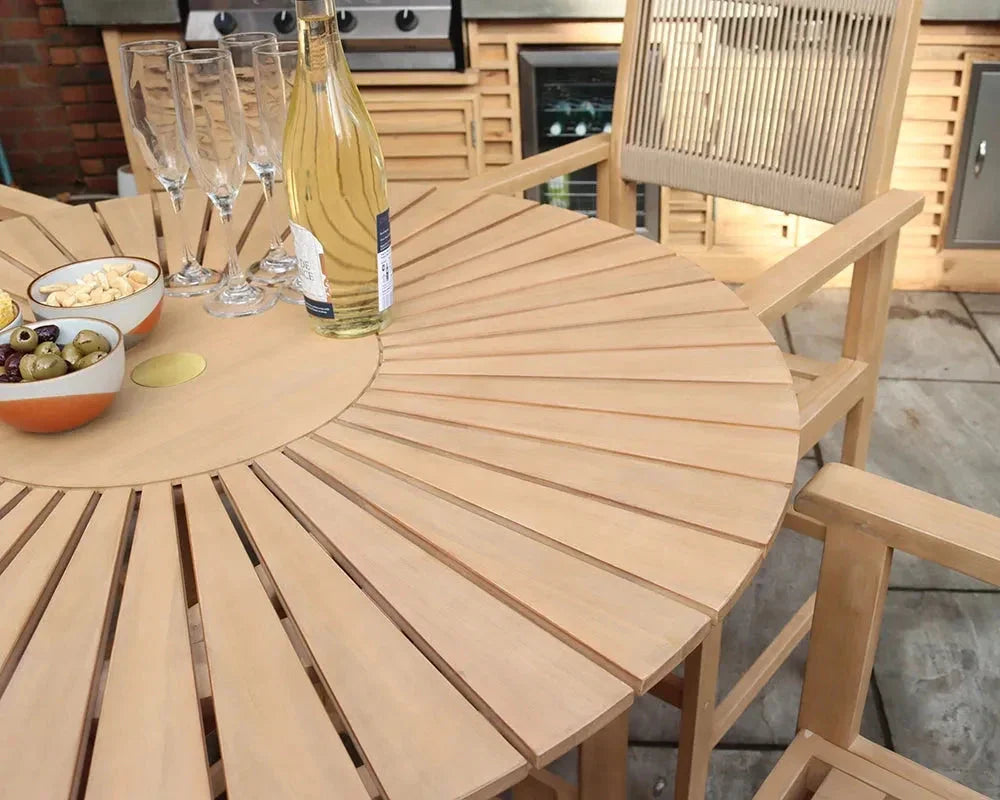 Round wooden garden dining table with matching chair, wine, glasses, and snacks outdoors