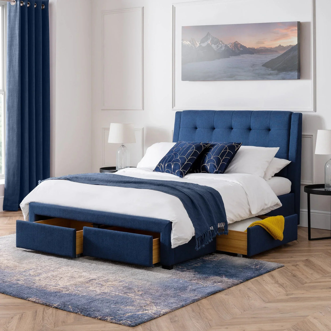 Blue upholstered double bed with four storage drawers in modern bedroom