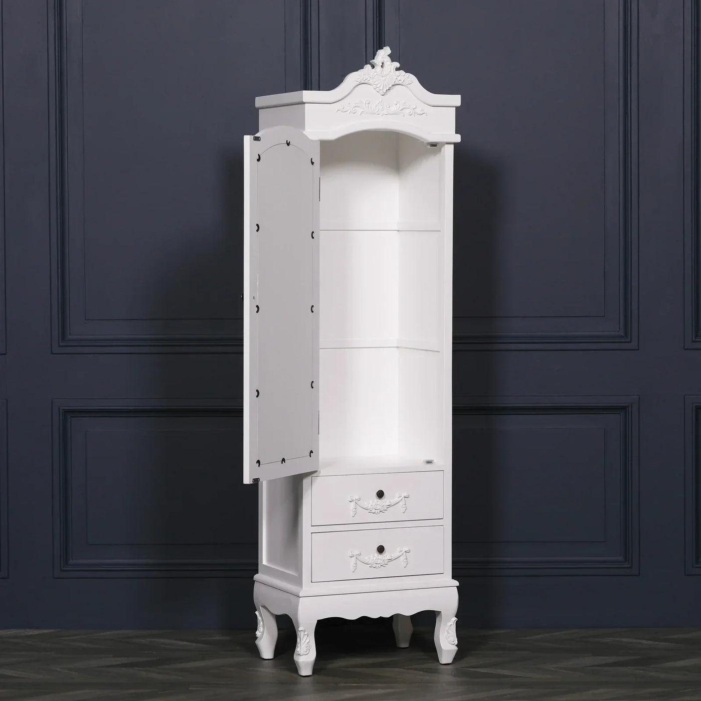 White narrow storage cabinet with open door, shelves and two drawers, against dark wall