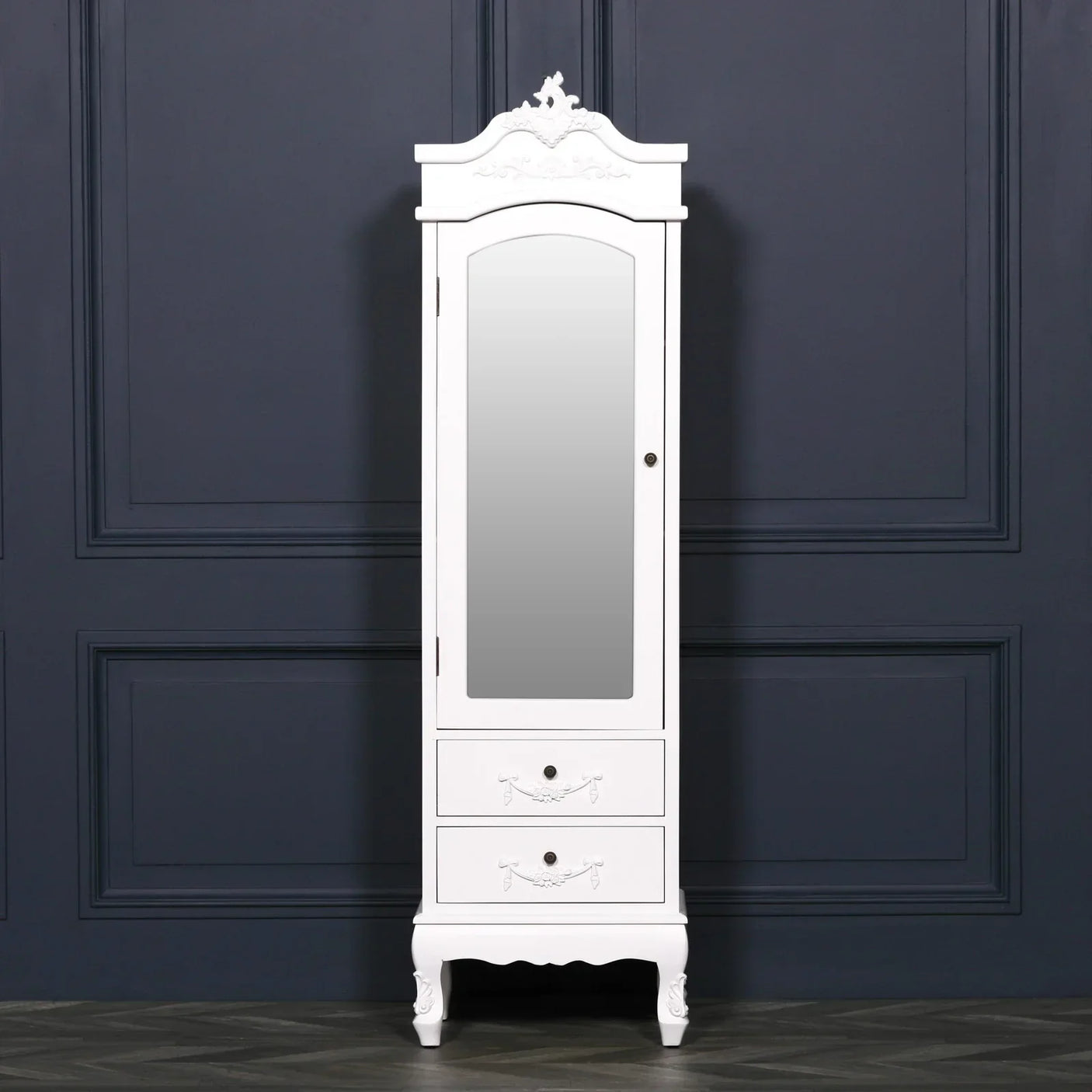 White mirrored wardrobe with two drawers and ornate details against dark wall