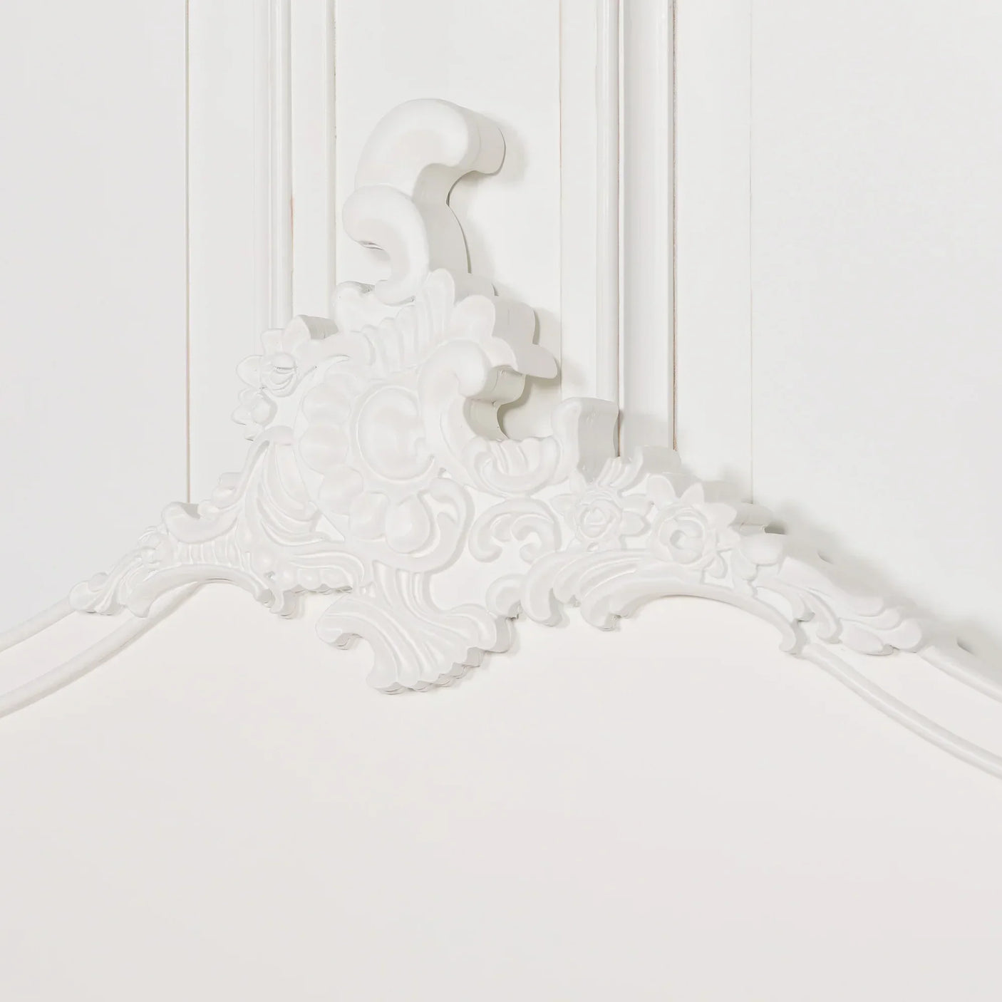 White wooden headboard with ornate carved floral detailing and textured finish