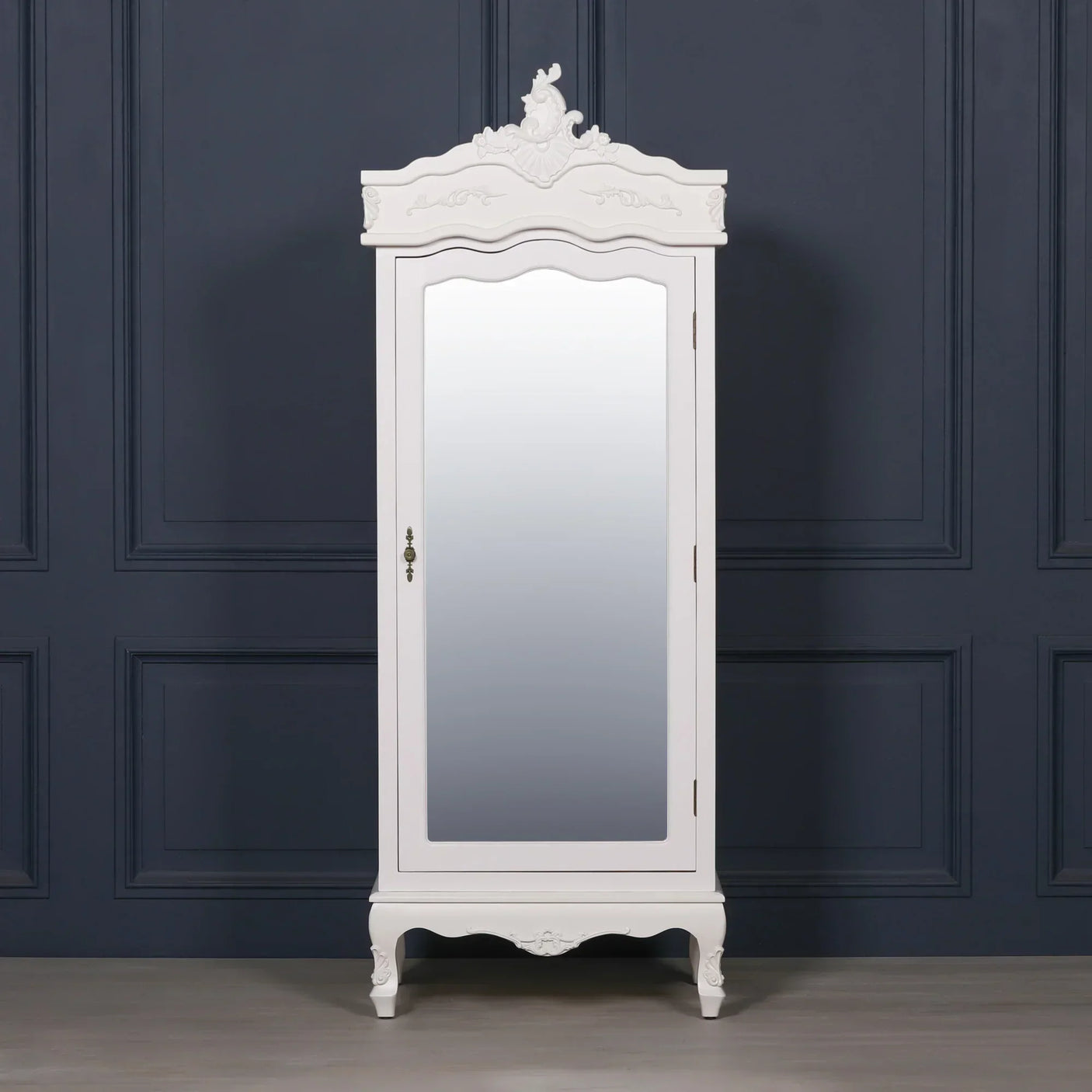 White wardrobe with mirrored door and ornate detailing against dark panelled wall
