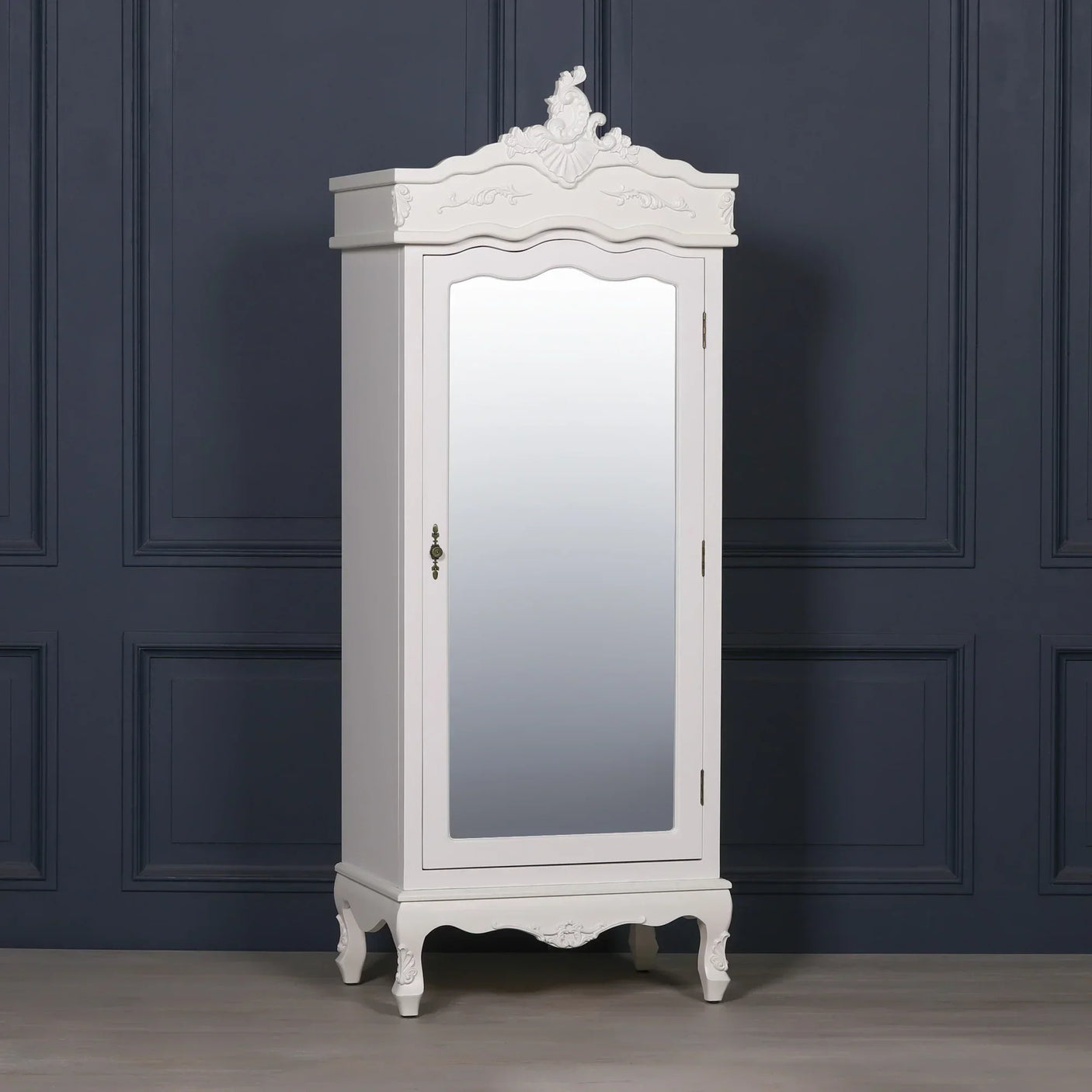 White mirrored wardrobe with ornate detailing and curved legs against navy panel wall