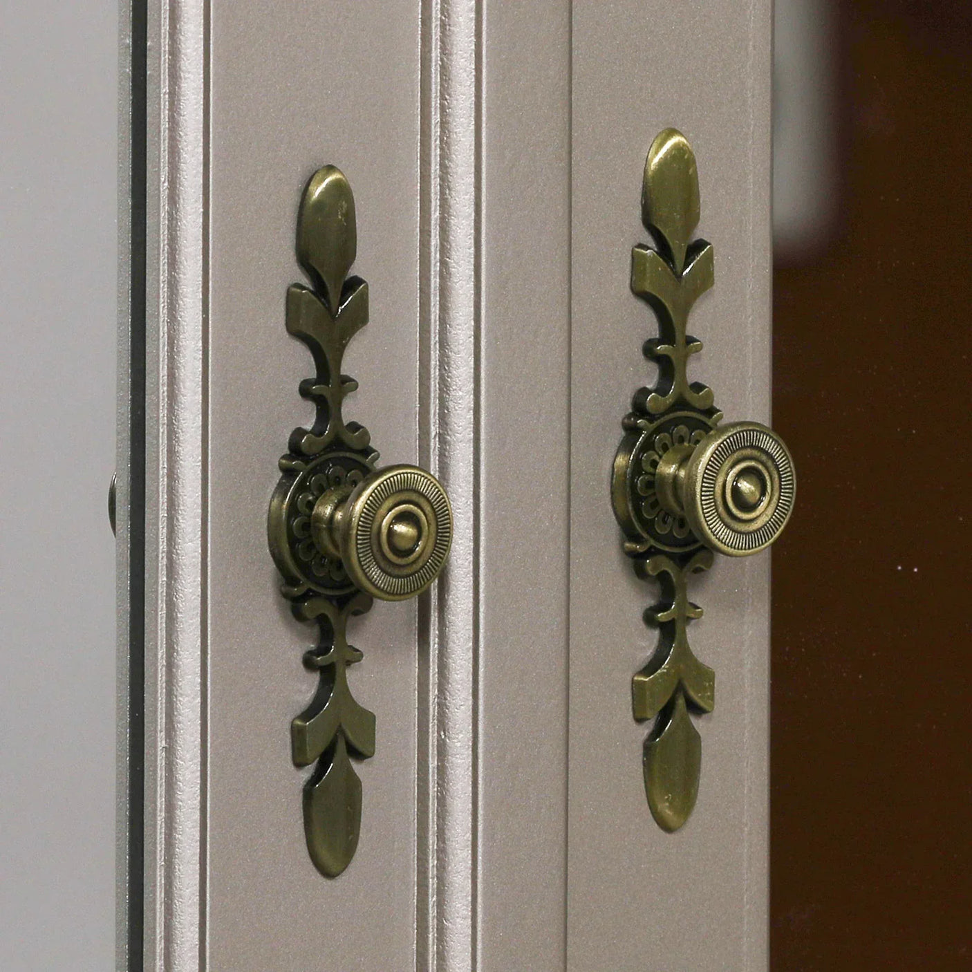 Close up of brass cabinet handles on mirrored wardrobe doors