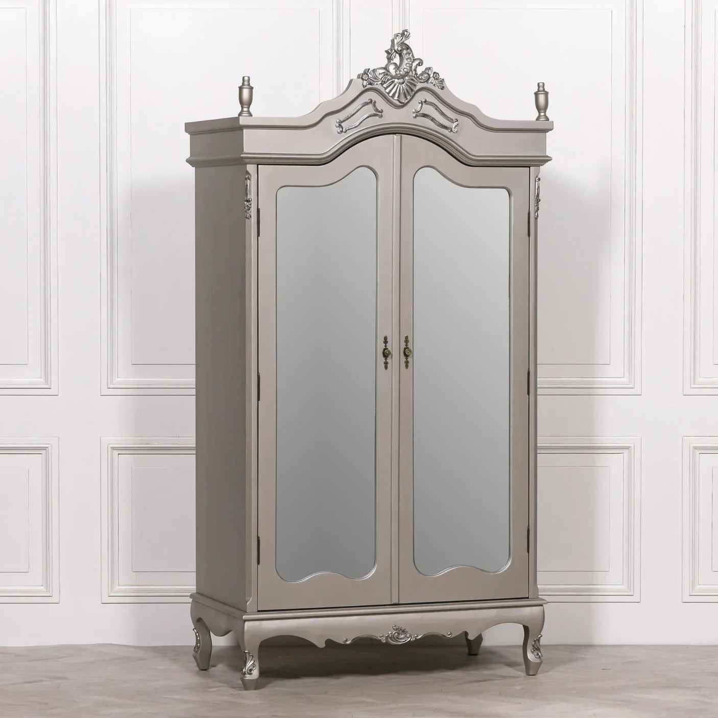 Grey mirrored wardrobe with ornate detailing and double doors against white panelled wall