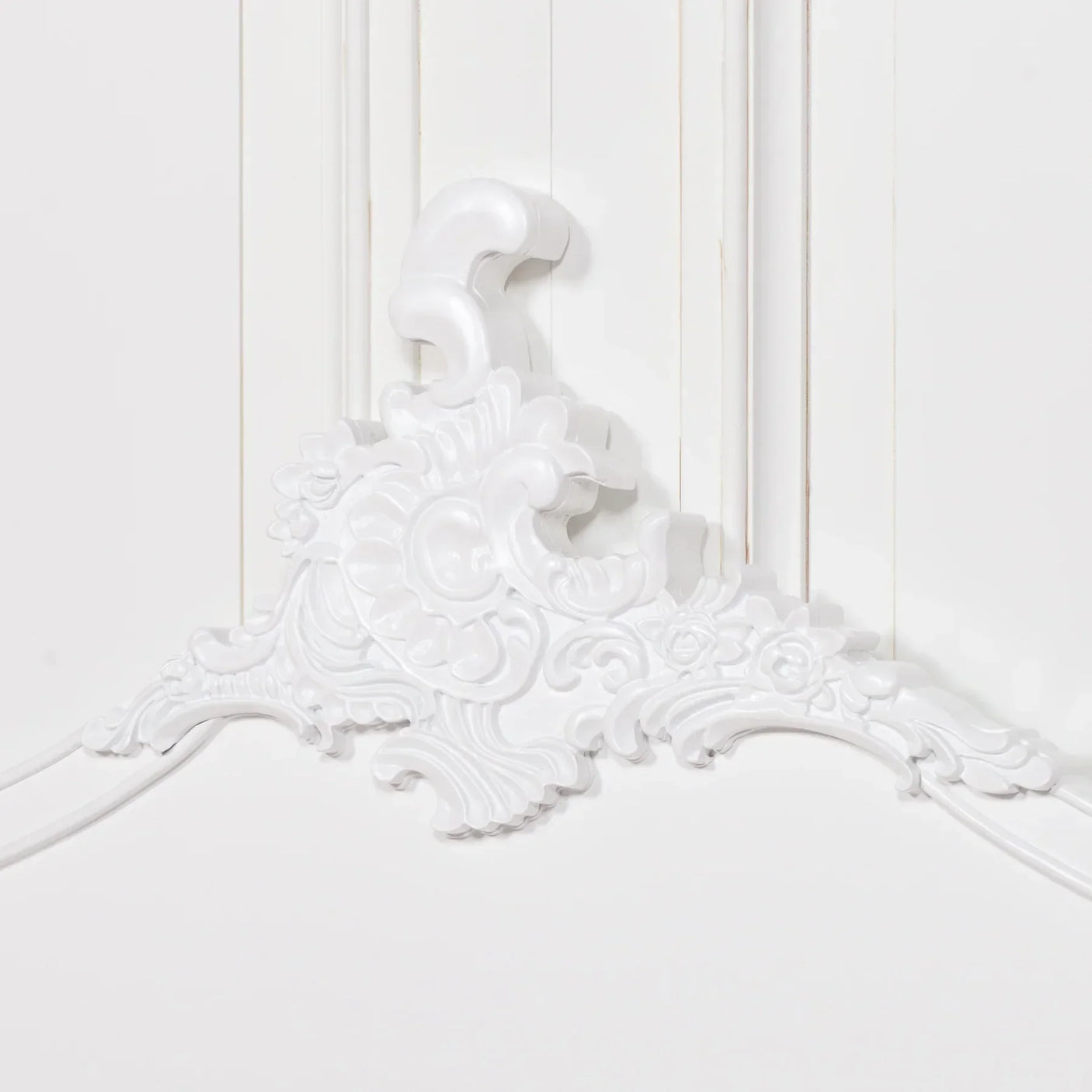 White French style headboard with ornate floral carving detail on wood panel background