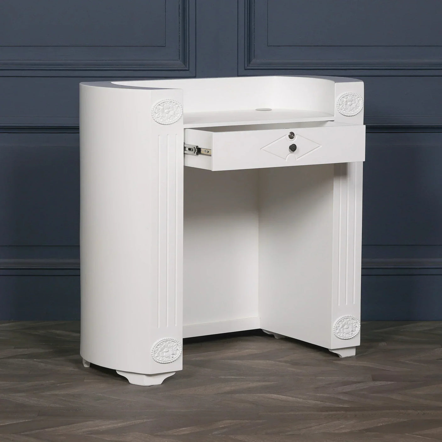 White wooden console table with locking drawer and decorative accents, side angle view