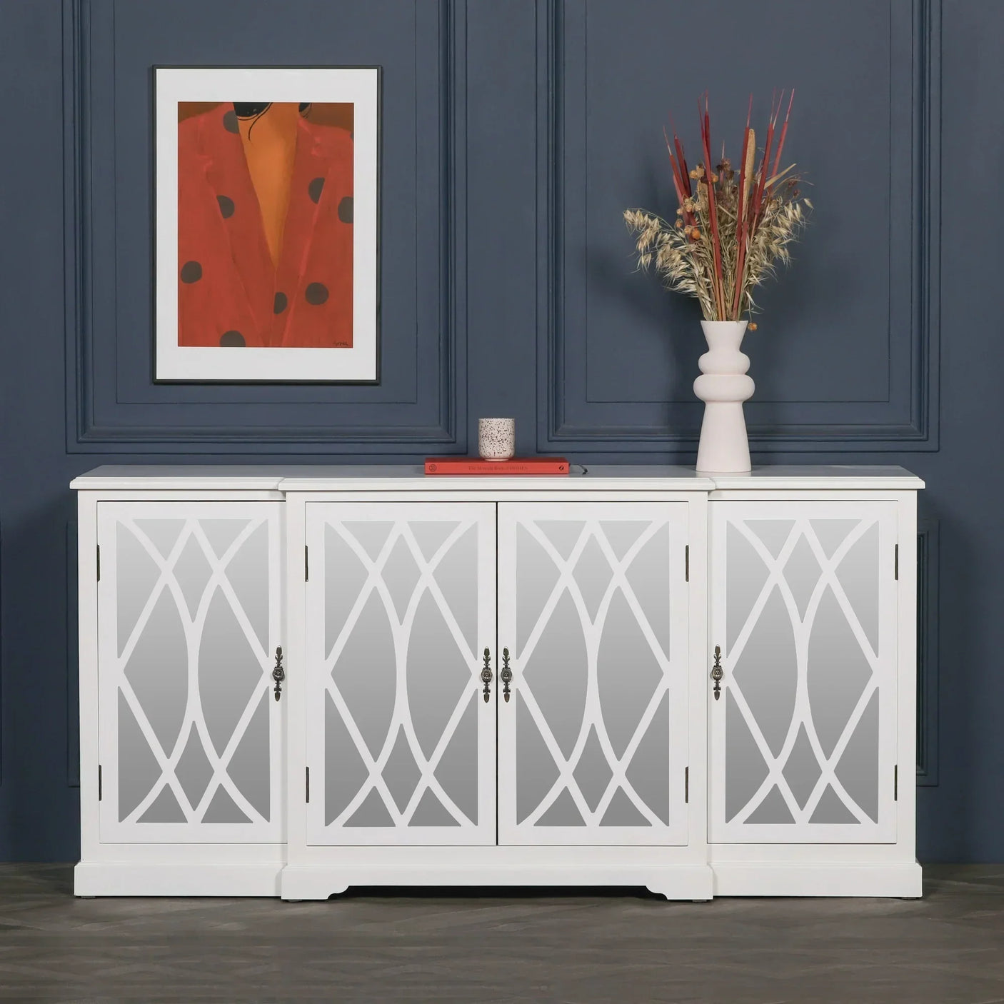 White mirrored sideboard with decorative lattice doors, styled with vase and framed art