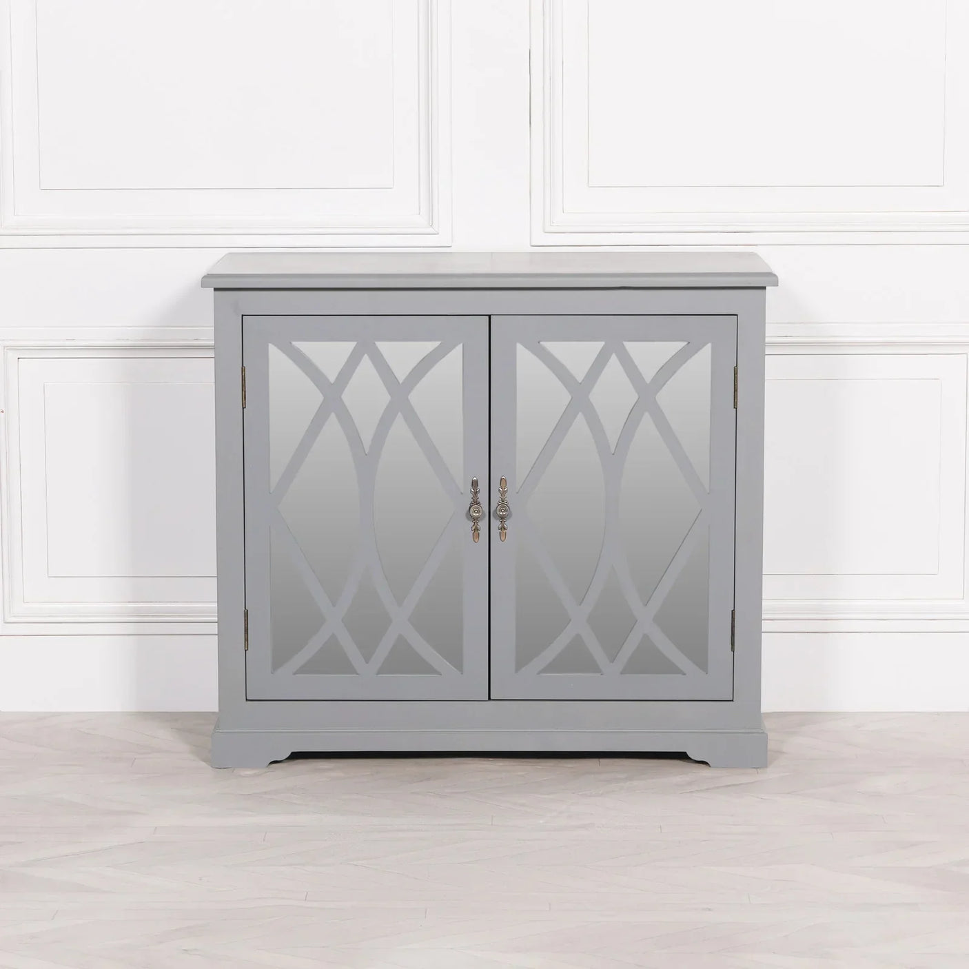 Grey mirrored sideboard with geometric pattern doors and silver handles against white wall