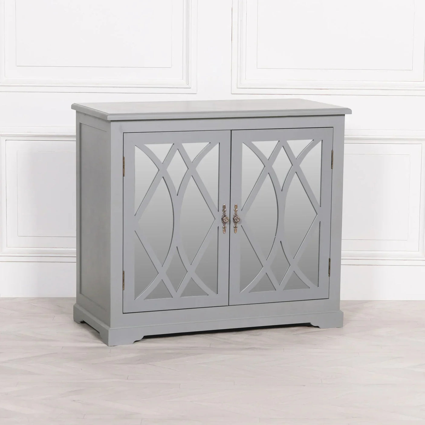 Grey mirrored sideboard cabinet with lattice design doors and brass handles on light flooring