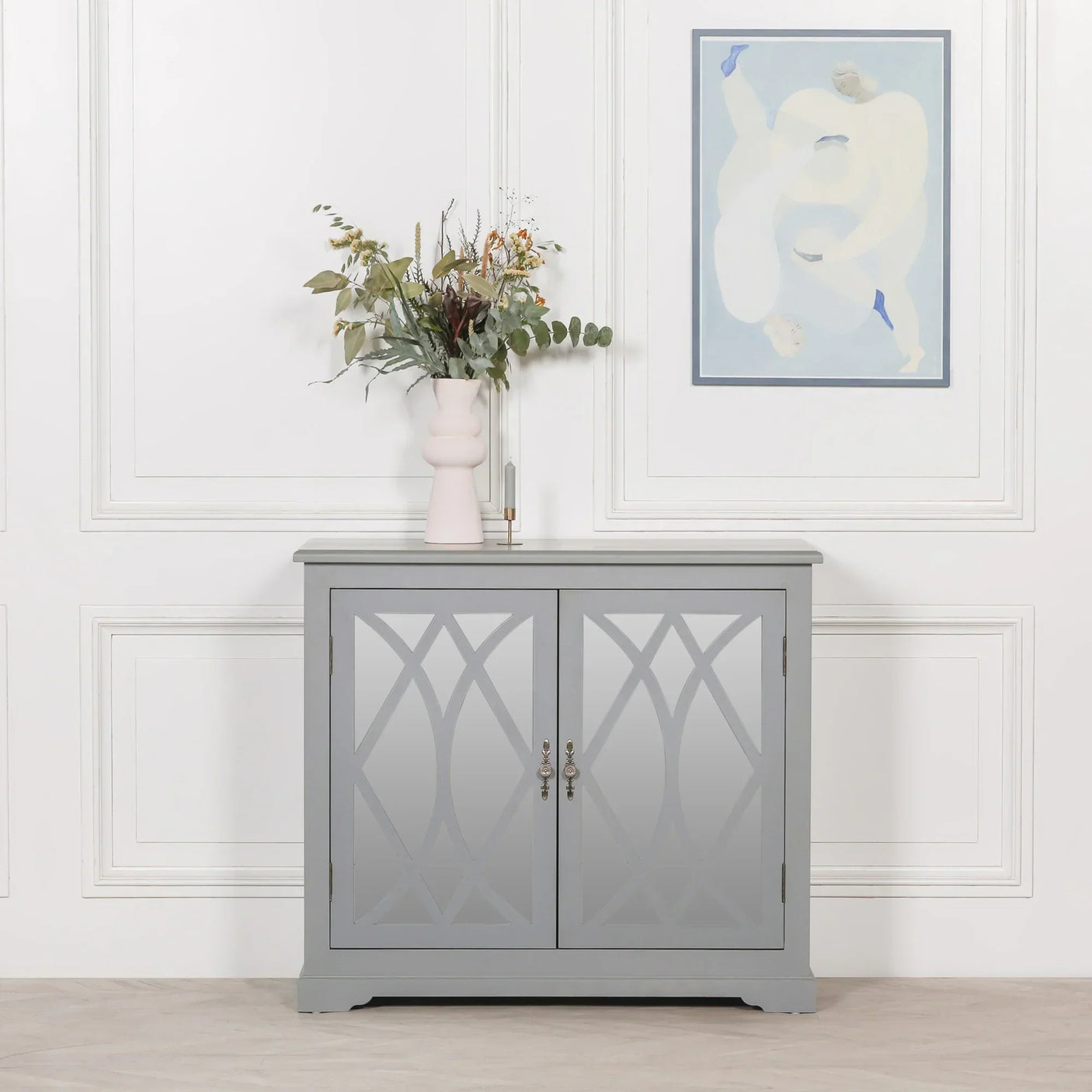 Grey sideboard cabinet with mirrored doors and floral vase in modern living room setting