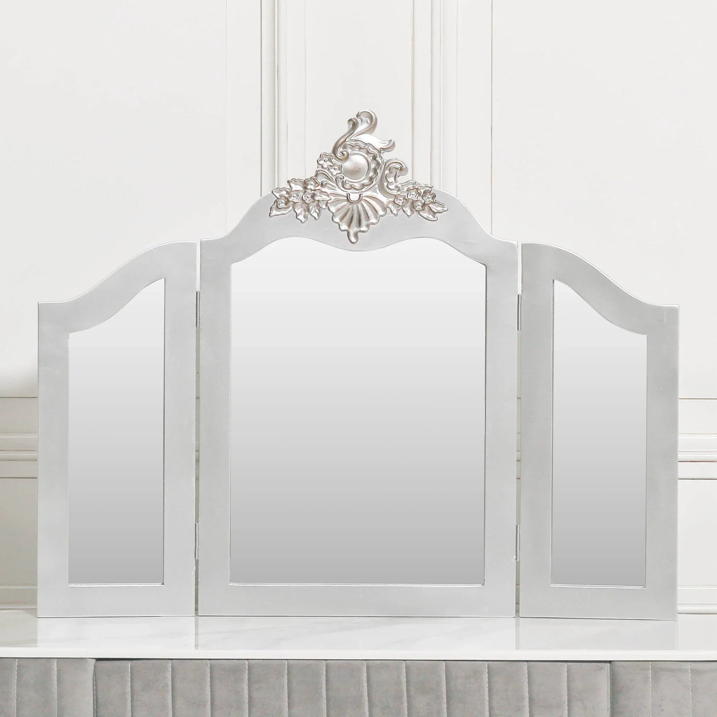 White dressing table mirror with three panels and ornate silver floral detailing
