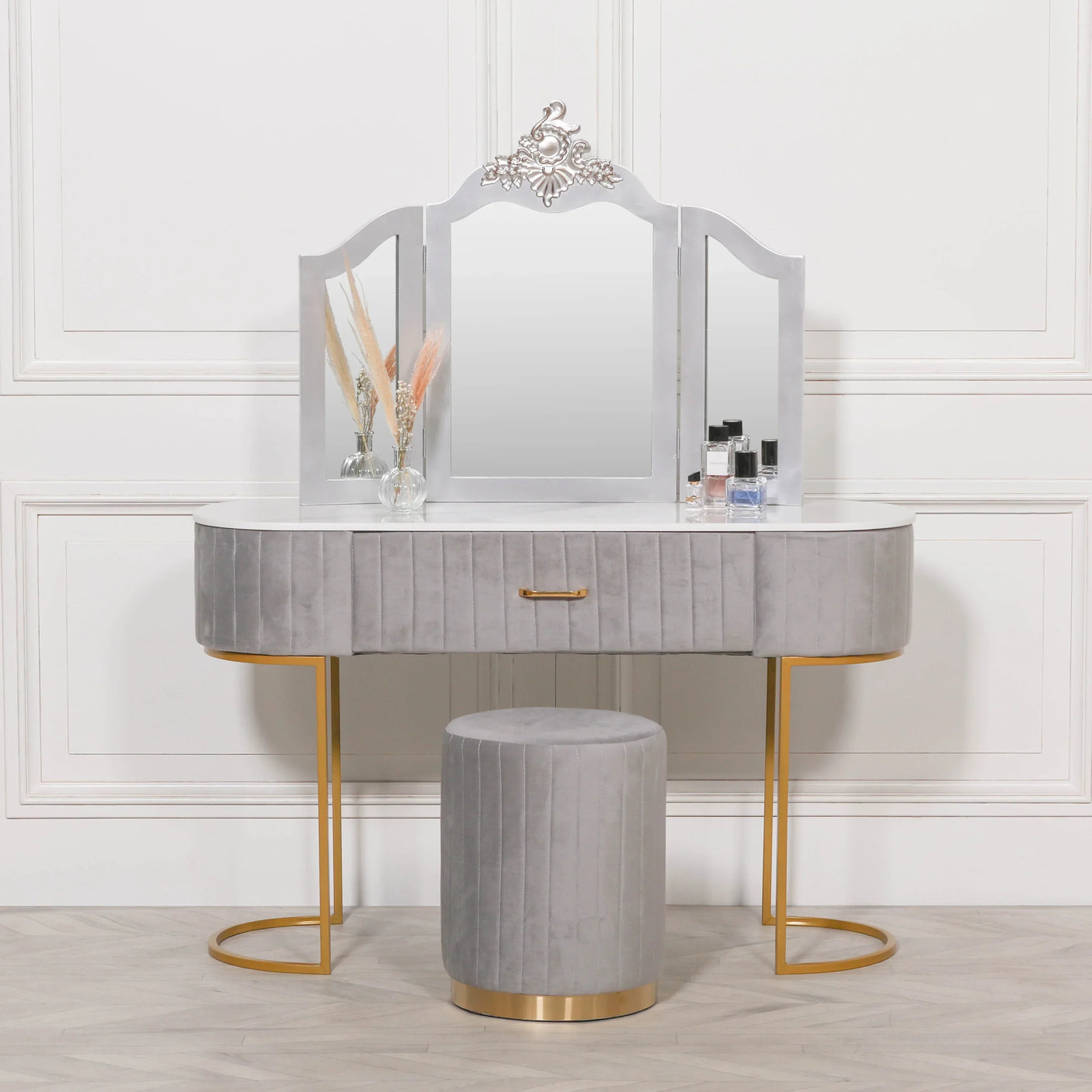 Grey velvet dressing table with gold legs, matching stool, and three-panel mirror