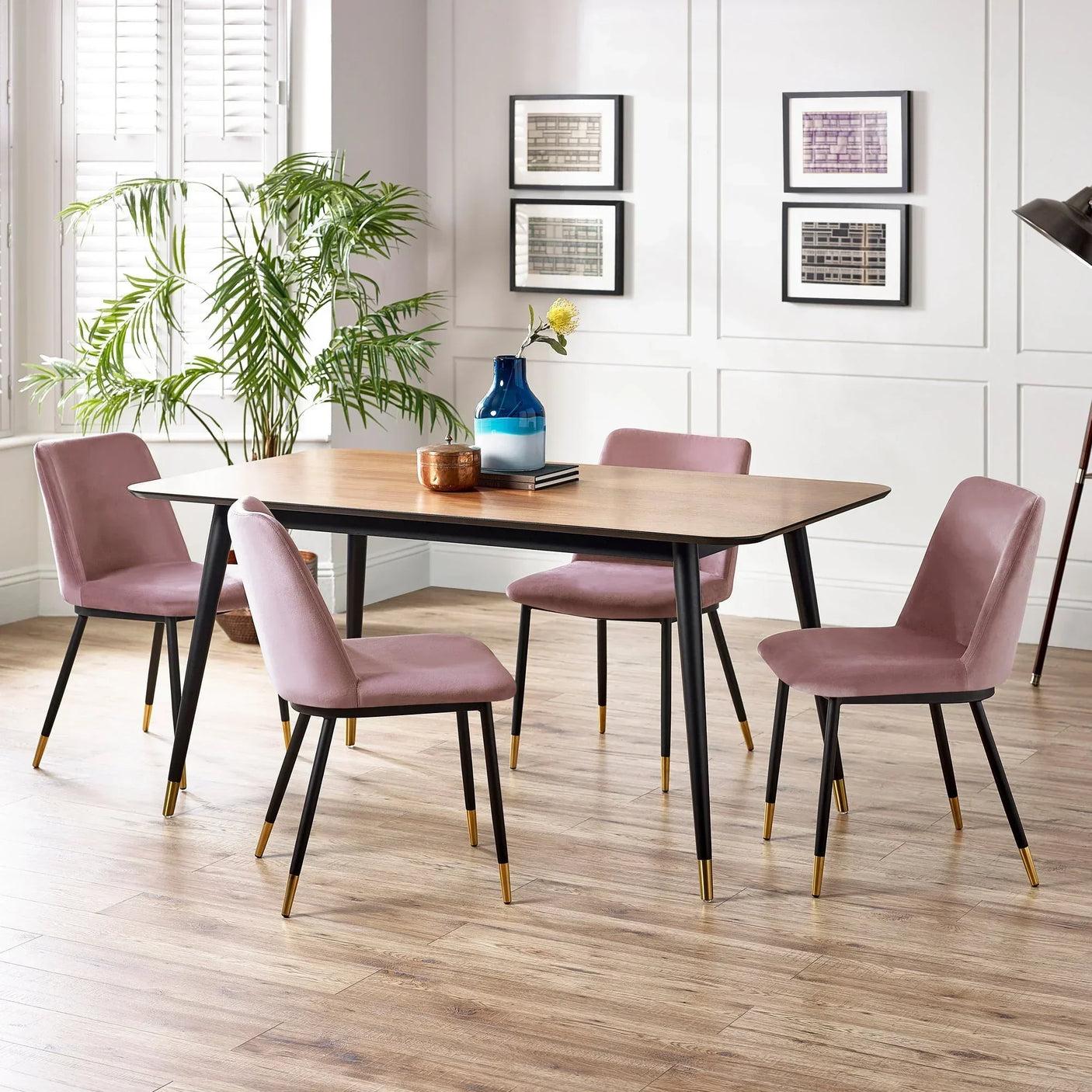 Rectangular dining table with wooden top and four dusky pink chairs in modern dining room