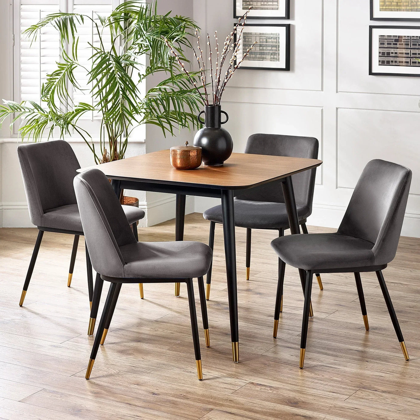 Square dining table with wooden top and four grey chairs in modern dining room