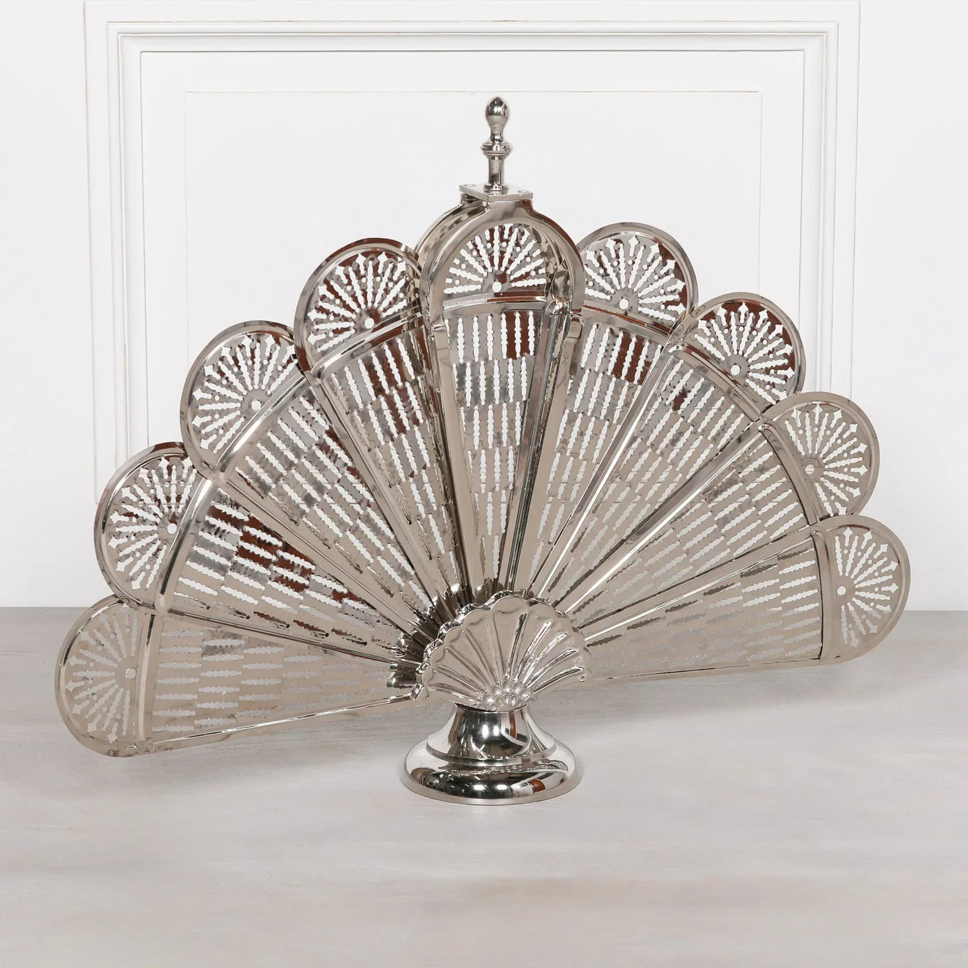 Silver metal firescreen with fan-shaped panels on a white background