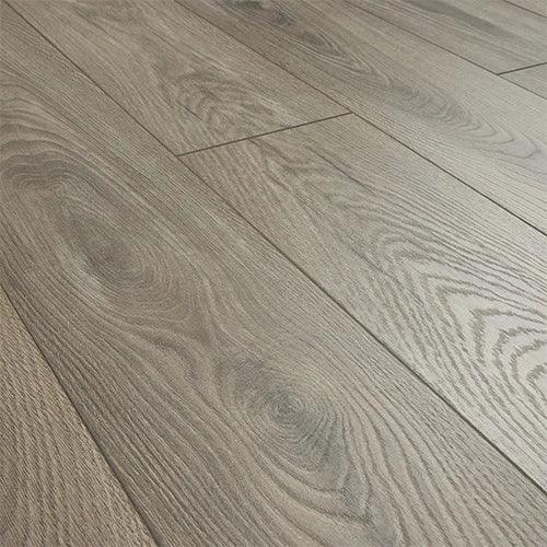 Fossil oak laminate flooring with grey-brown wood grain and matte finish, close-up view