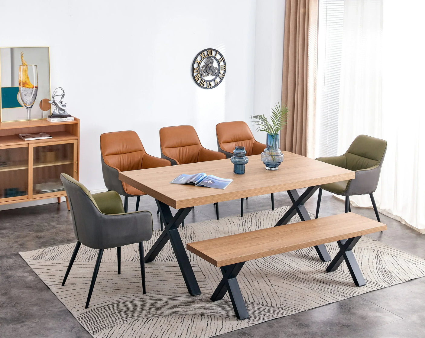 Oak dining table with black X-legs, bench seat, and brown and green upholstered chairs