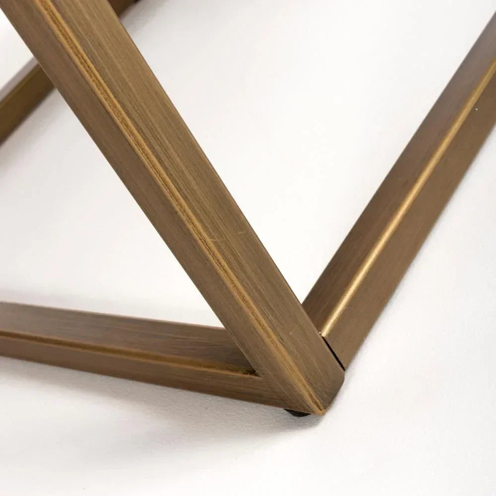 Brushed gold metal table leg frame detail on white background