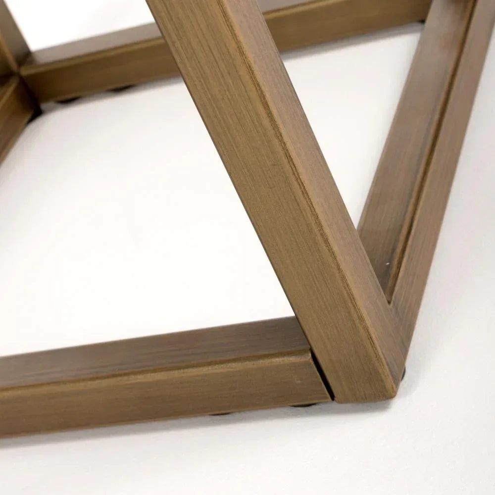 Close-up of brushed gold metal table leg on white background
