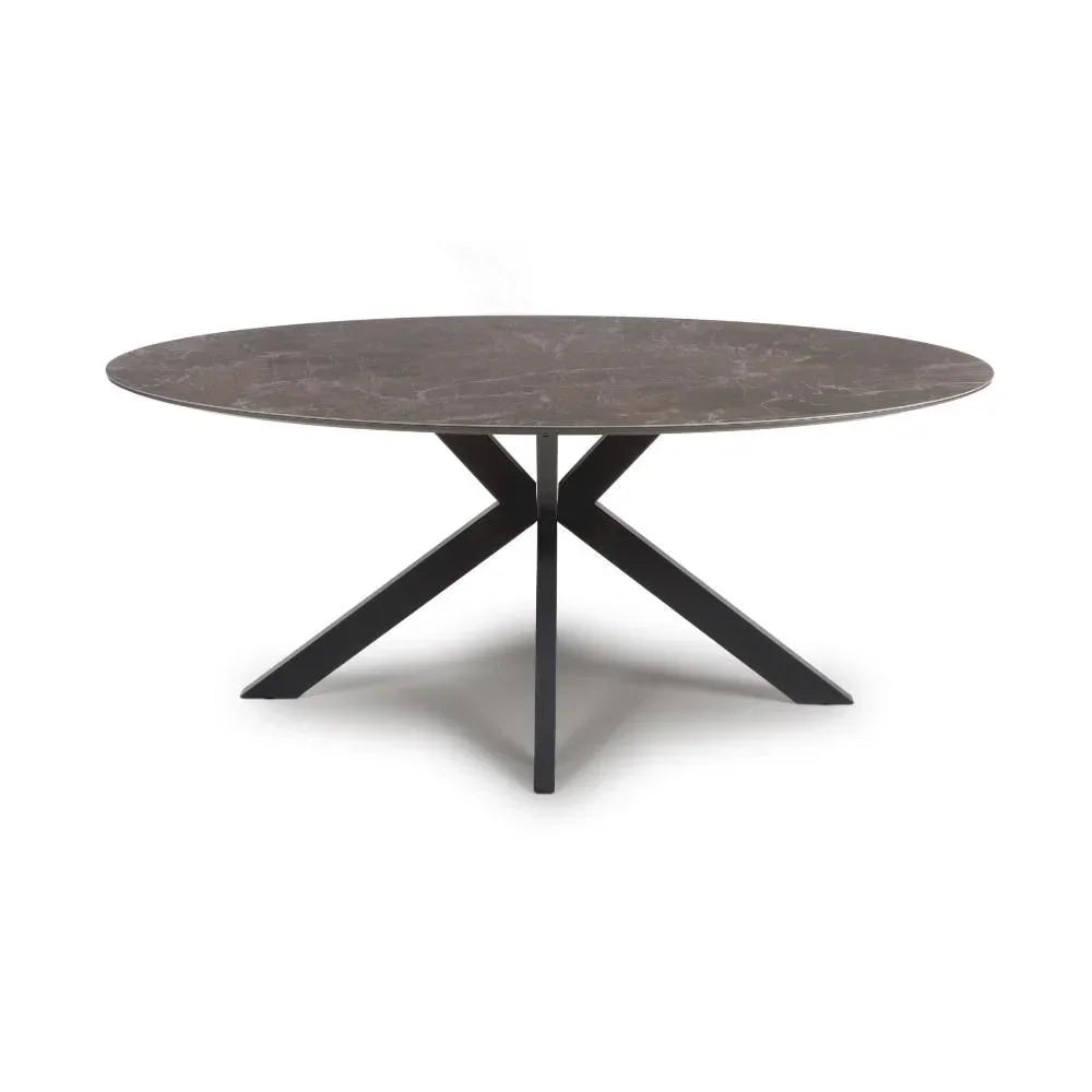 Oval dining table with dark marble top and black crossed metal legs