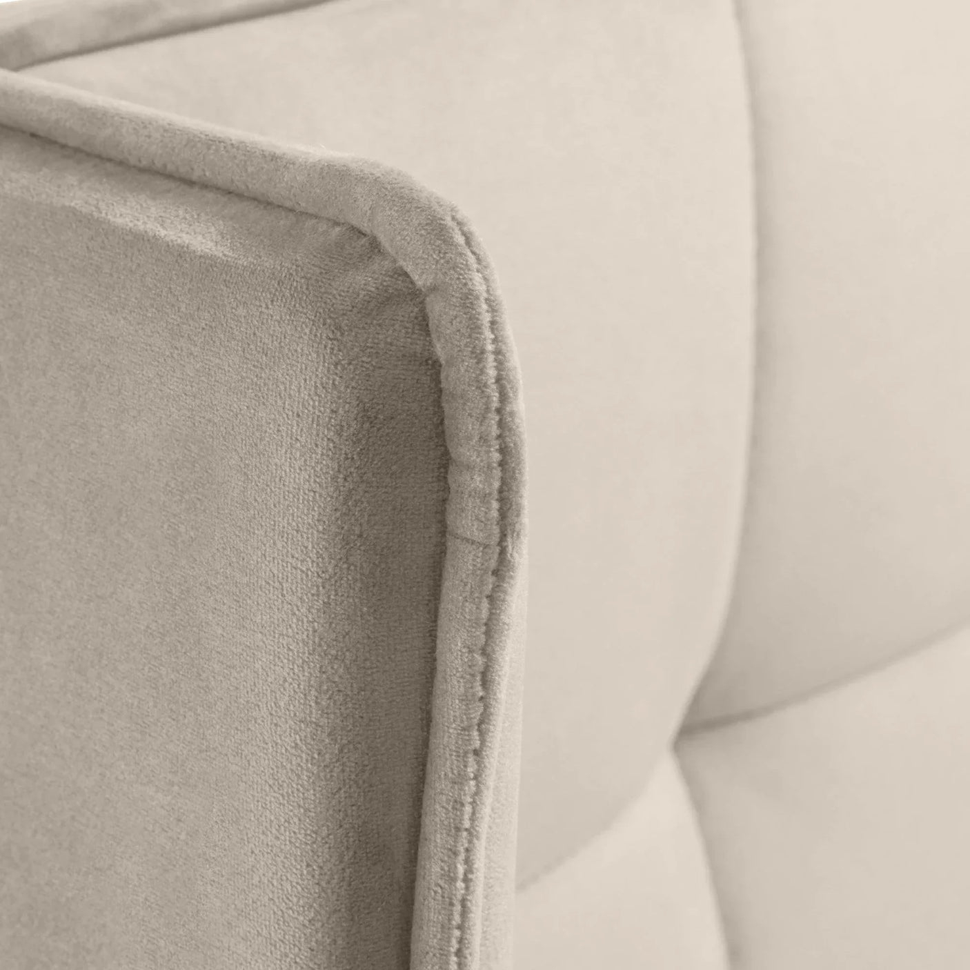 Beige fabric sofa corner with soft upholstery and visible stitched panel detail