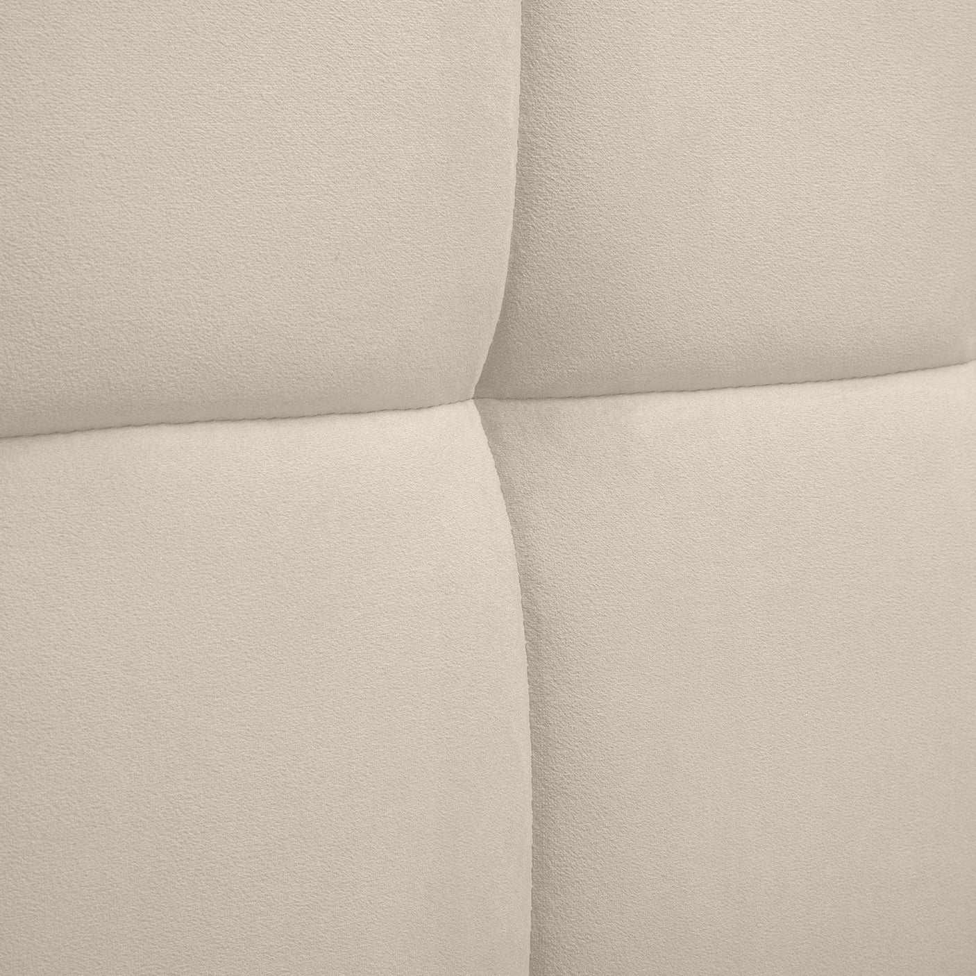 Beige upholstered headboard with soft panel stitching close up