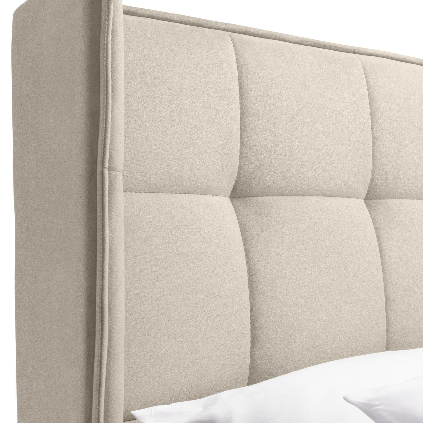 Beige upholstered bed headboard with quilted panel detail, side angle view