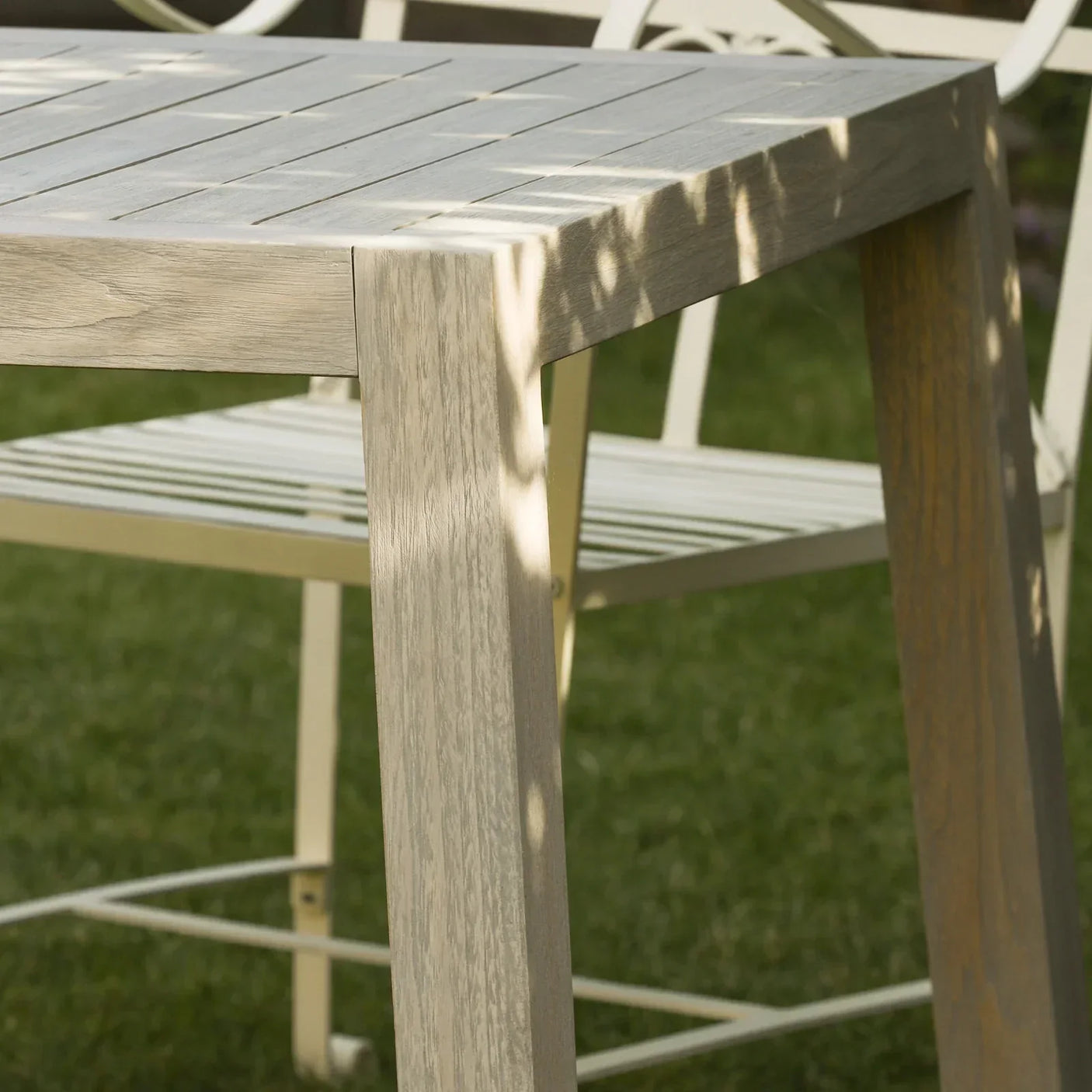 Light wood effect outdoor dining table with metal garden chair on grass