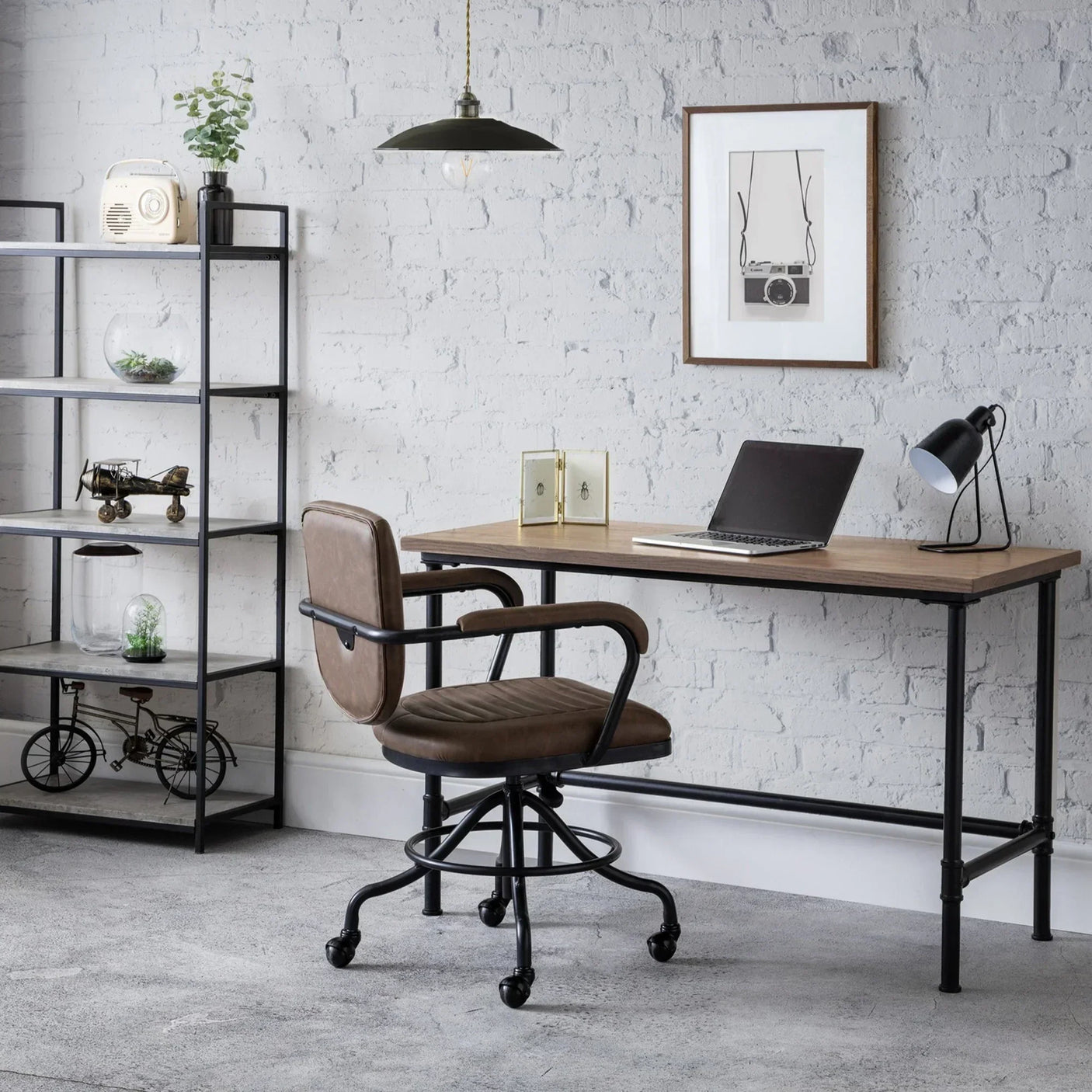 Swivel chair with brown faux leather seat at industrial desk in modern home office setup