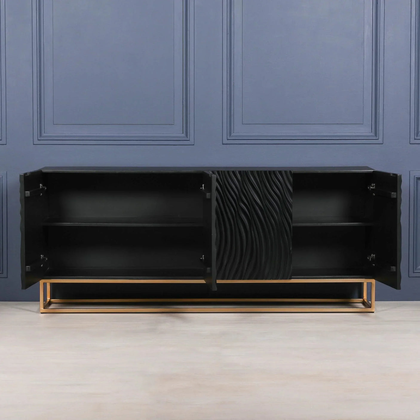 Black sideboard with gold metal base, open doors, and textured wave detail on front