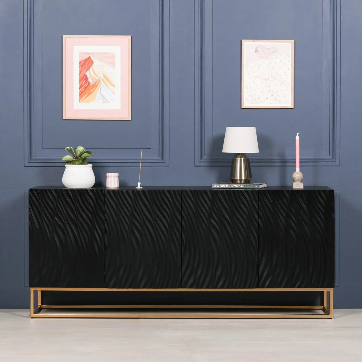 Black sideboard with textured doors and gold metal base in modern living room