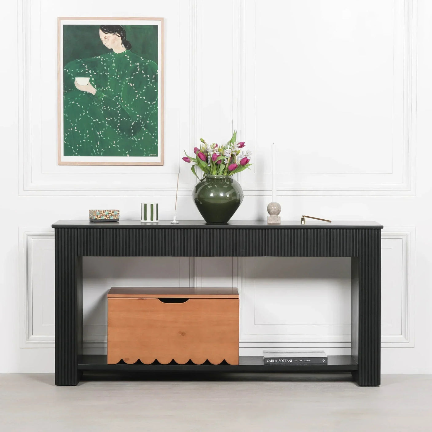 Black wood console table with fluted legs, styled with vase of tulips and storage box