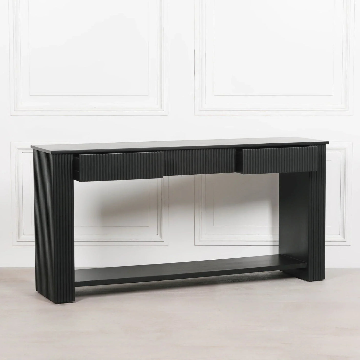 Black wood console table with fluted paneling and lower shelf in modern interior setting
