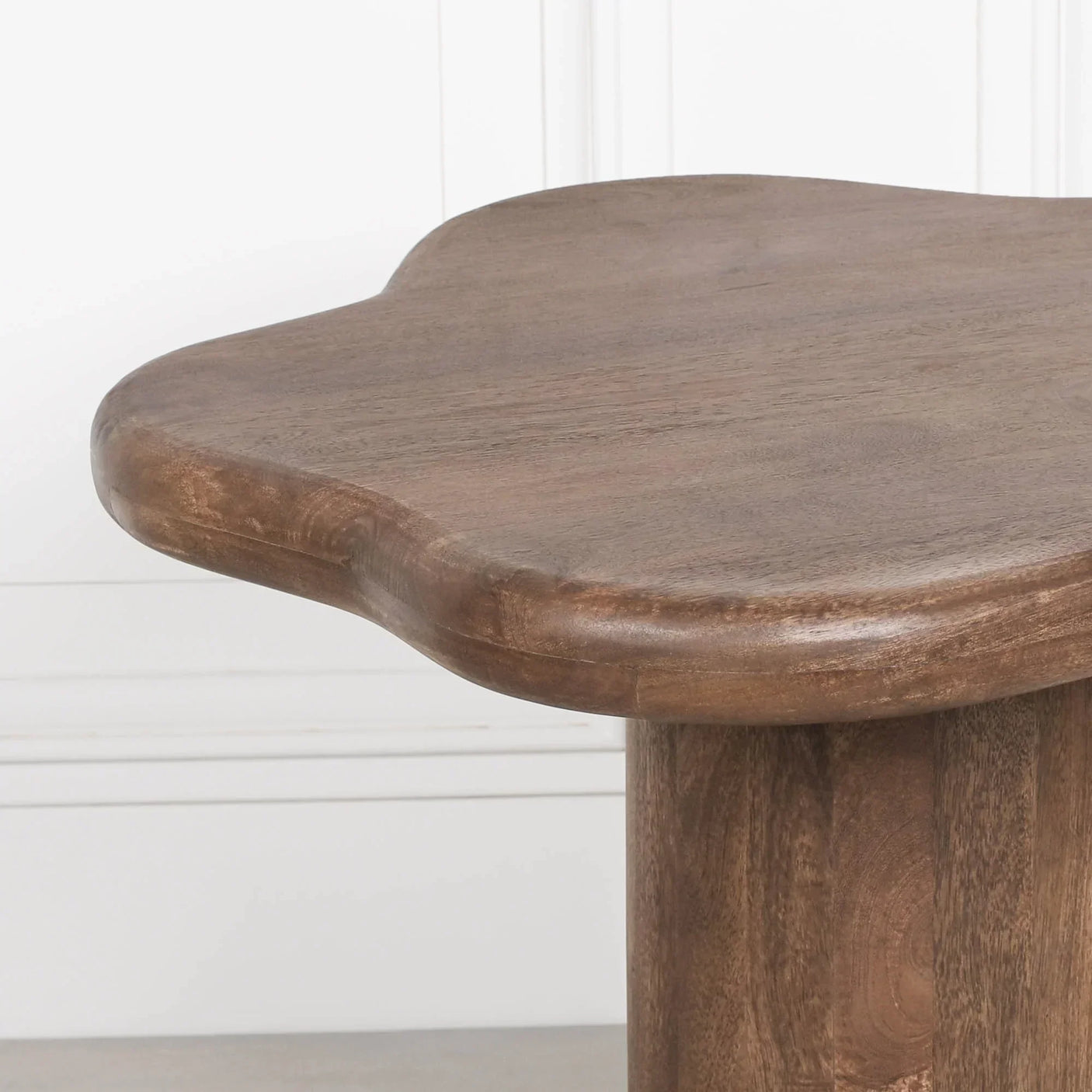 Closeup of natural wood coffee table with curved edge design and smooth finish